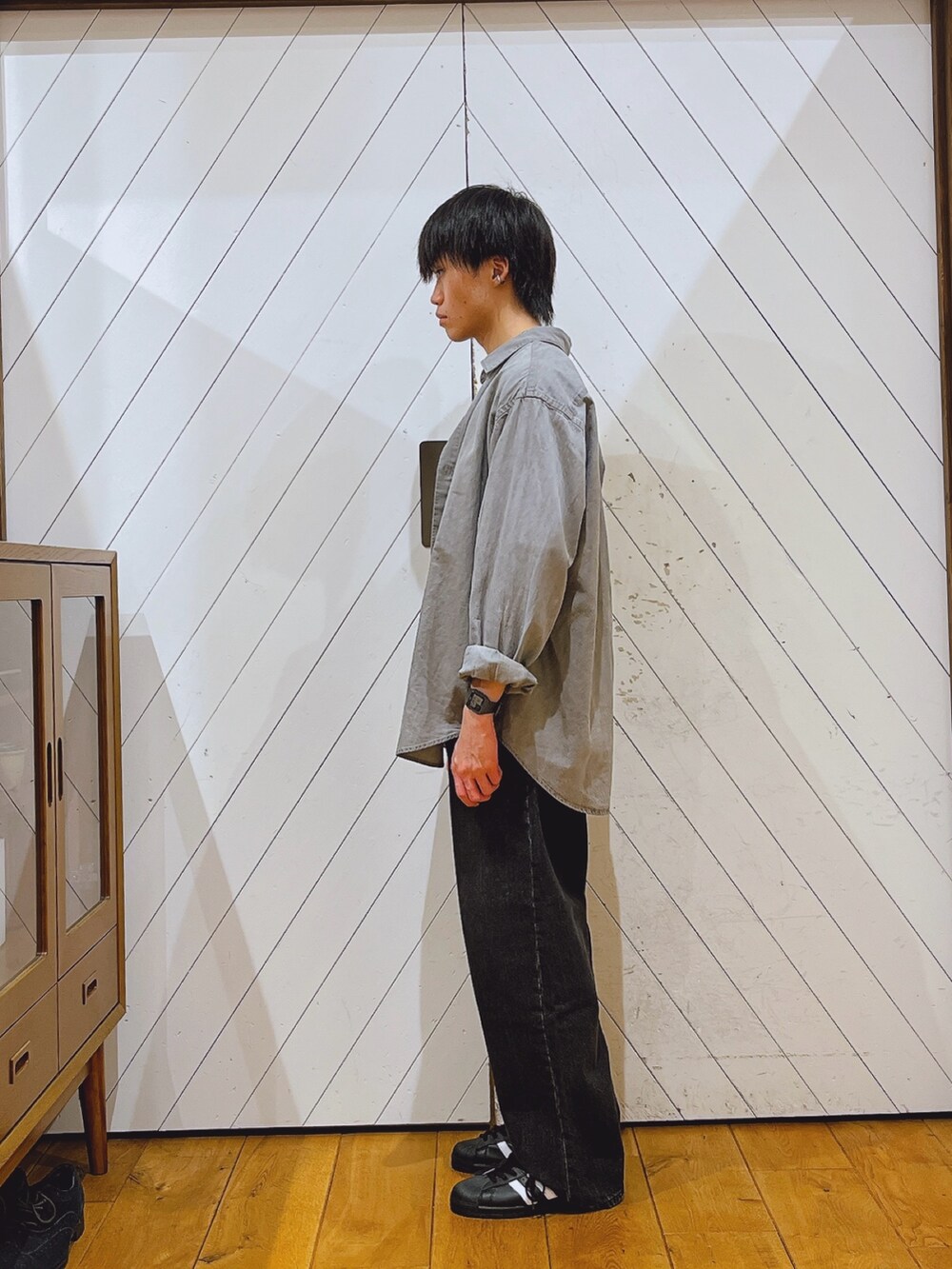 グレー系のシャツ/ブラウス、ブラック系のデニムパンツ、ブラック系のスニーカーを着用したメンズの秋コーディネートの2枚目の写真