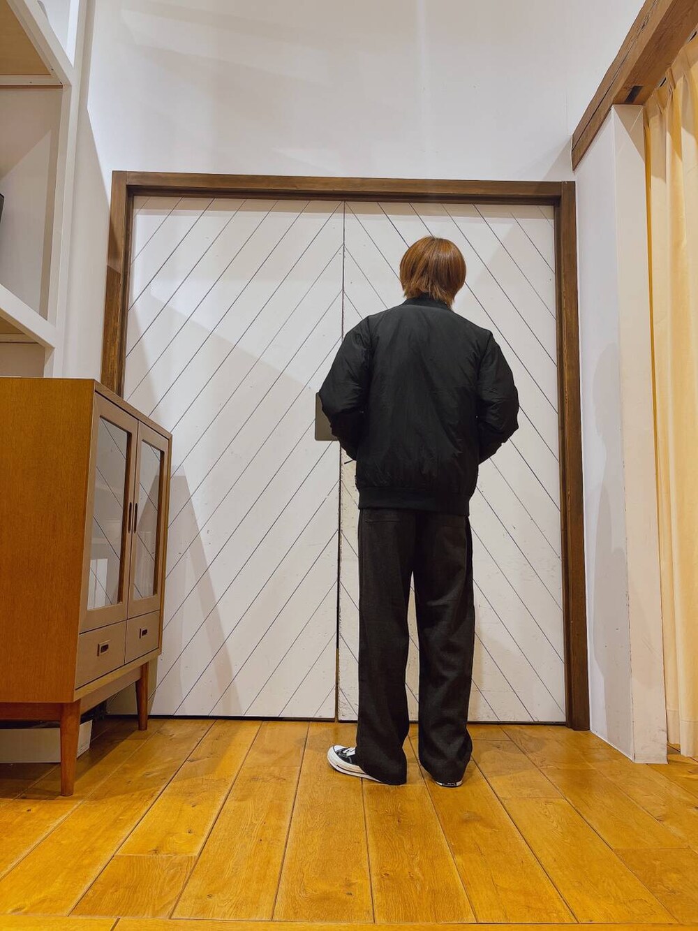 グレー系のニット/セーター、グレー系のその他パンツ、ブラック系のダウンジャケット/コートを着用したメンズの秋コーディネートの5枚目の写真