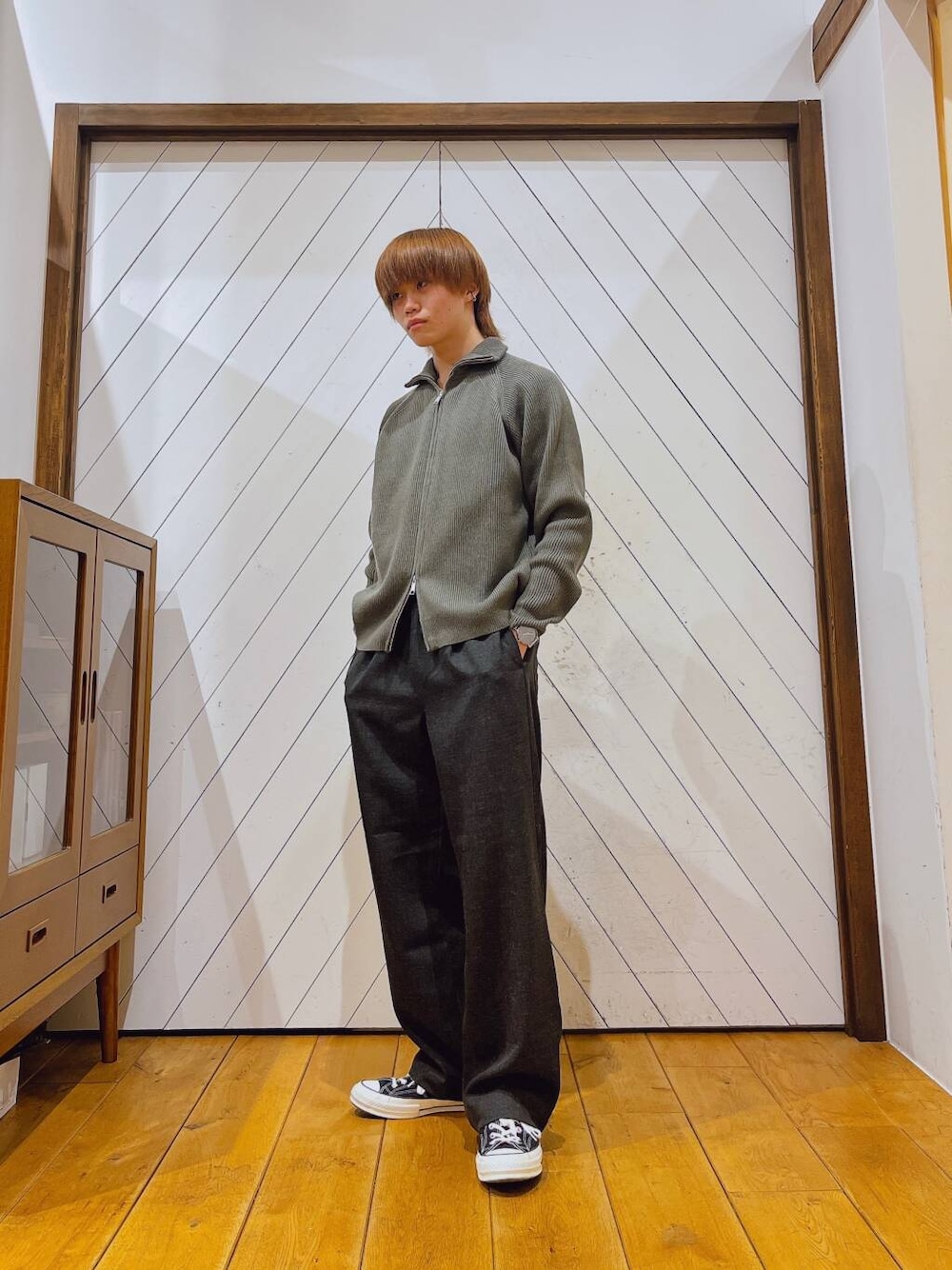 グレー系のニット/セーター、グレー系のその他パンツ、ブラック系のダウンジャケット/コートを着用したメンズの秋コーディネートの4枚目の写真