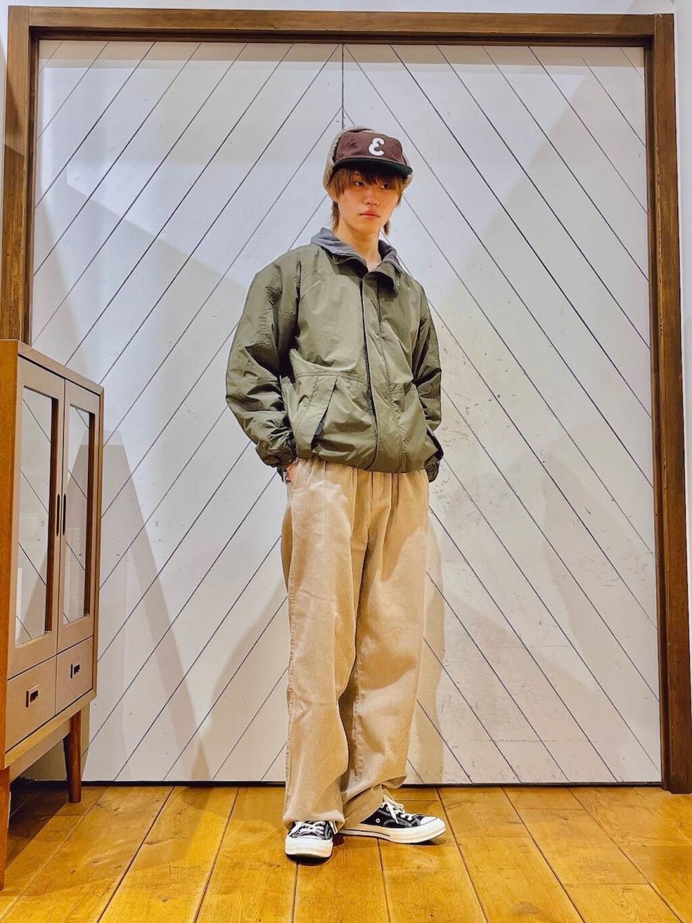 ホワイト系のその他パンツ、グリーン系のブルゾン、ブラウン系のキャップを着用したメンズの冬コーディネートの3枚目の写真