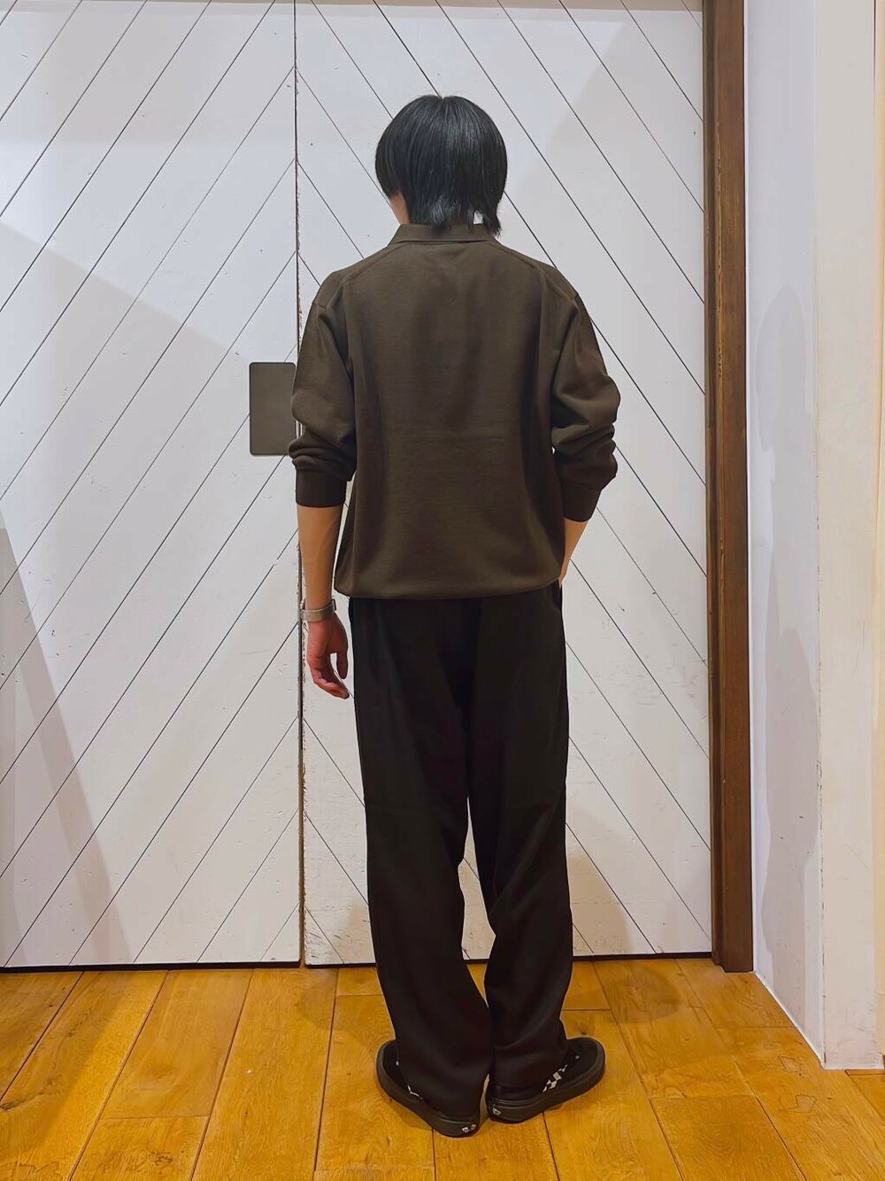 ブラウン系のポロシャツ、ブラック系のその他パンツを着用したメンズの秋コーディネートの2枚目の写真