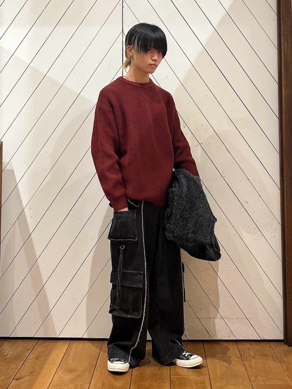 レッド系のニット/セーター、グレー系のカーディガン/ボレロを着用したメンズの冬コーディネートの2枚目の写真