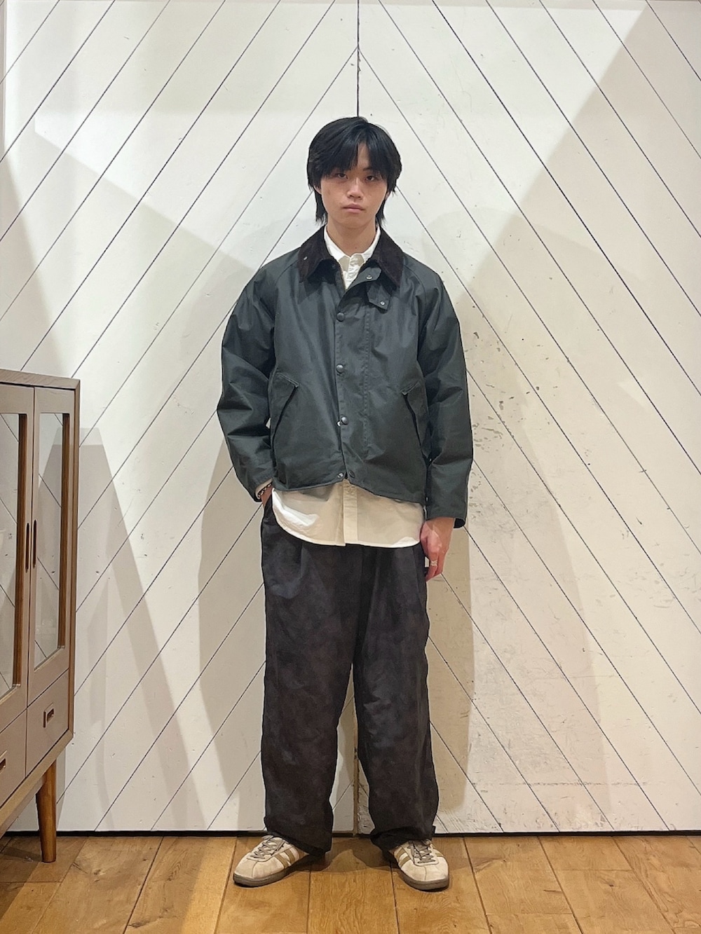 グリーン系のその他アウター、ブラック系のその他パンツ、ベージュ系のスニーカーを着用したメンズの秋コーディネートの2枚目の写真