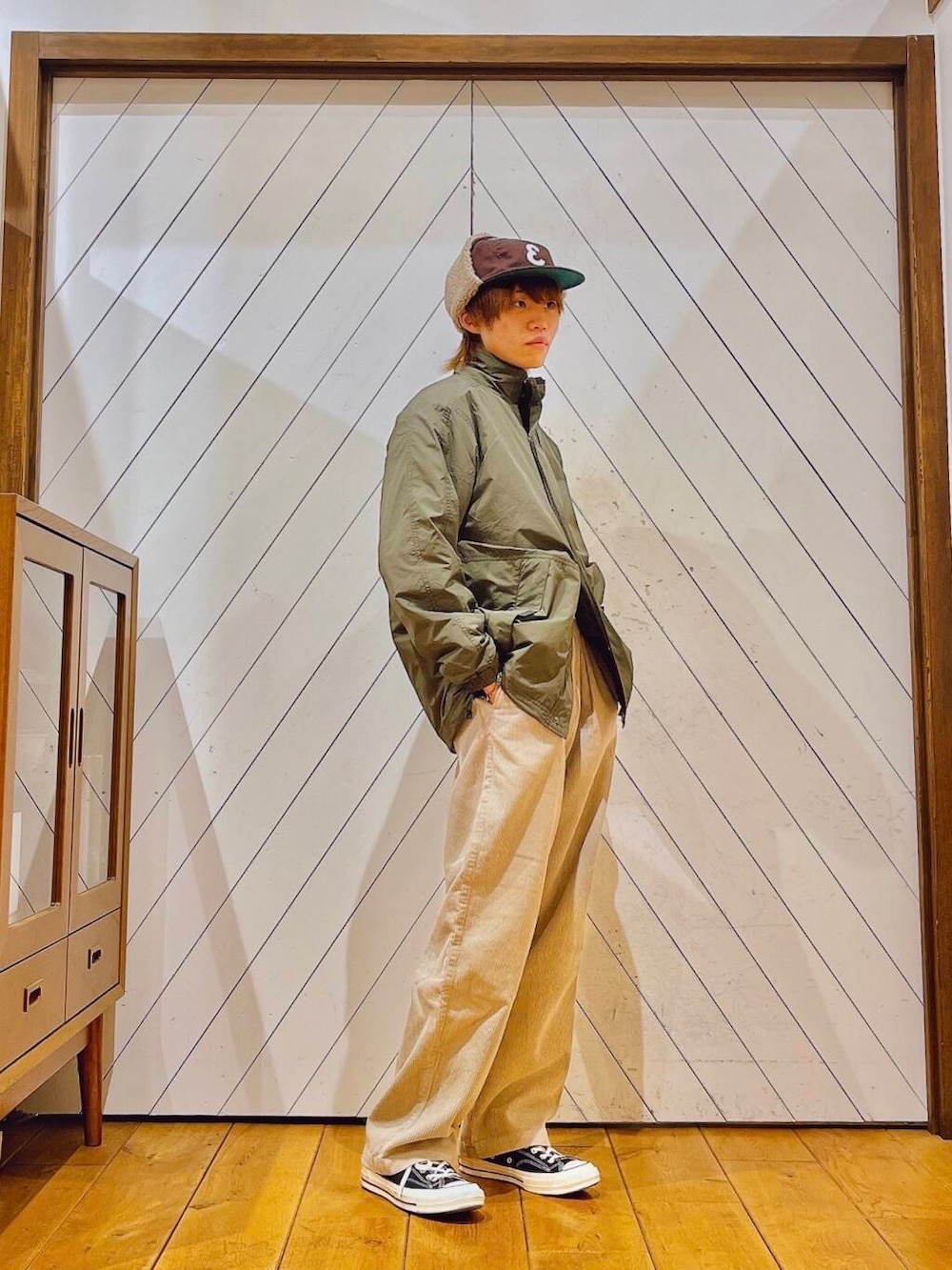 ホワイト系のその他パンツ、グリーン系のブルゾン、ブラウン系のキャップを着用したメンズの冬コーディネートの2枚目の写真