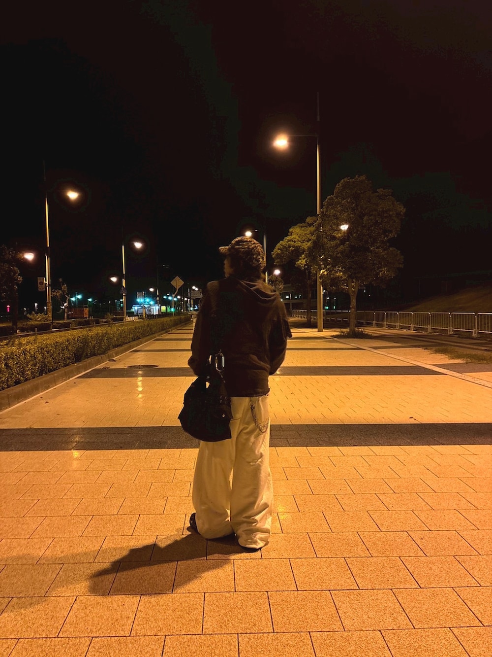 ブラウン系のパーカー、ホワイト系のスウェットパンツ、ブラック系のショルダーバッグを着用したメンズの秋コーディネートの2枚目の写真