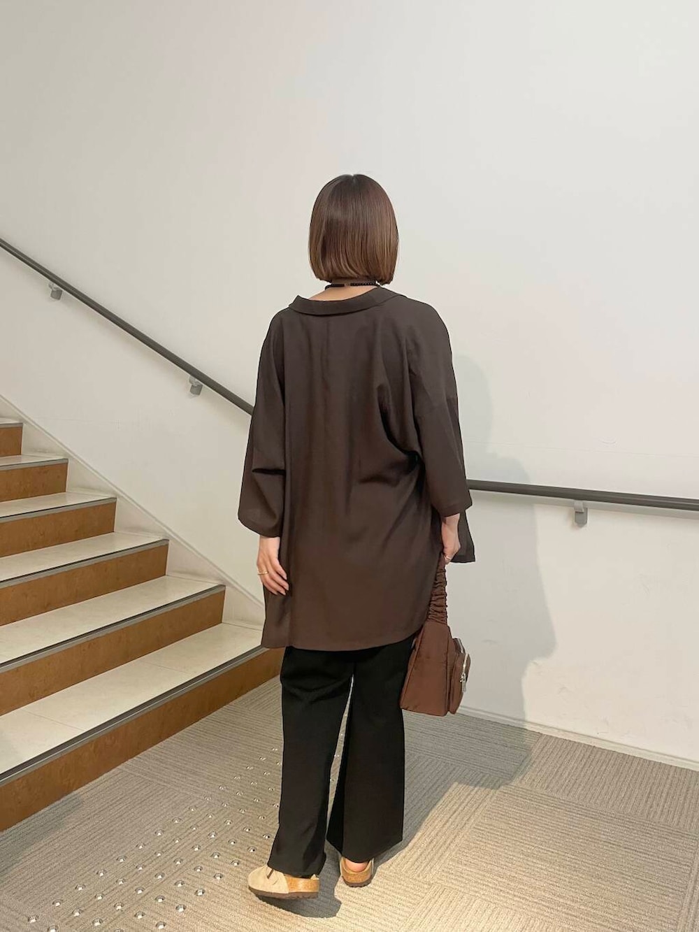 ブラウン系のショルダーバッグ、ベージュ系のサンダル、ブラウン系のシャツ/ブラウスを着用したレディースの夏コーディネートの2枚目の写真