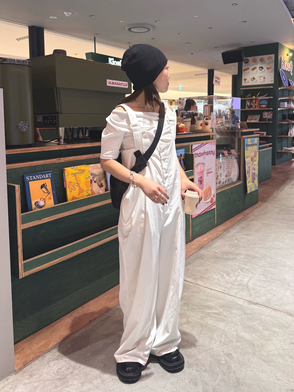 ホワイト系のオールインワン・サロペット、ブラック系のショルダーバッグ、シルバー系のチャームを着用したレディースの秋コーディネートの2枚目の写真