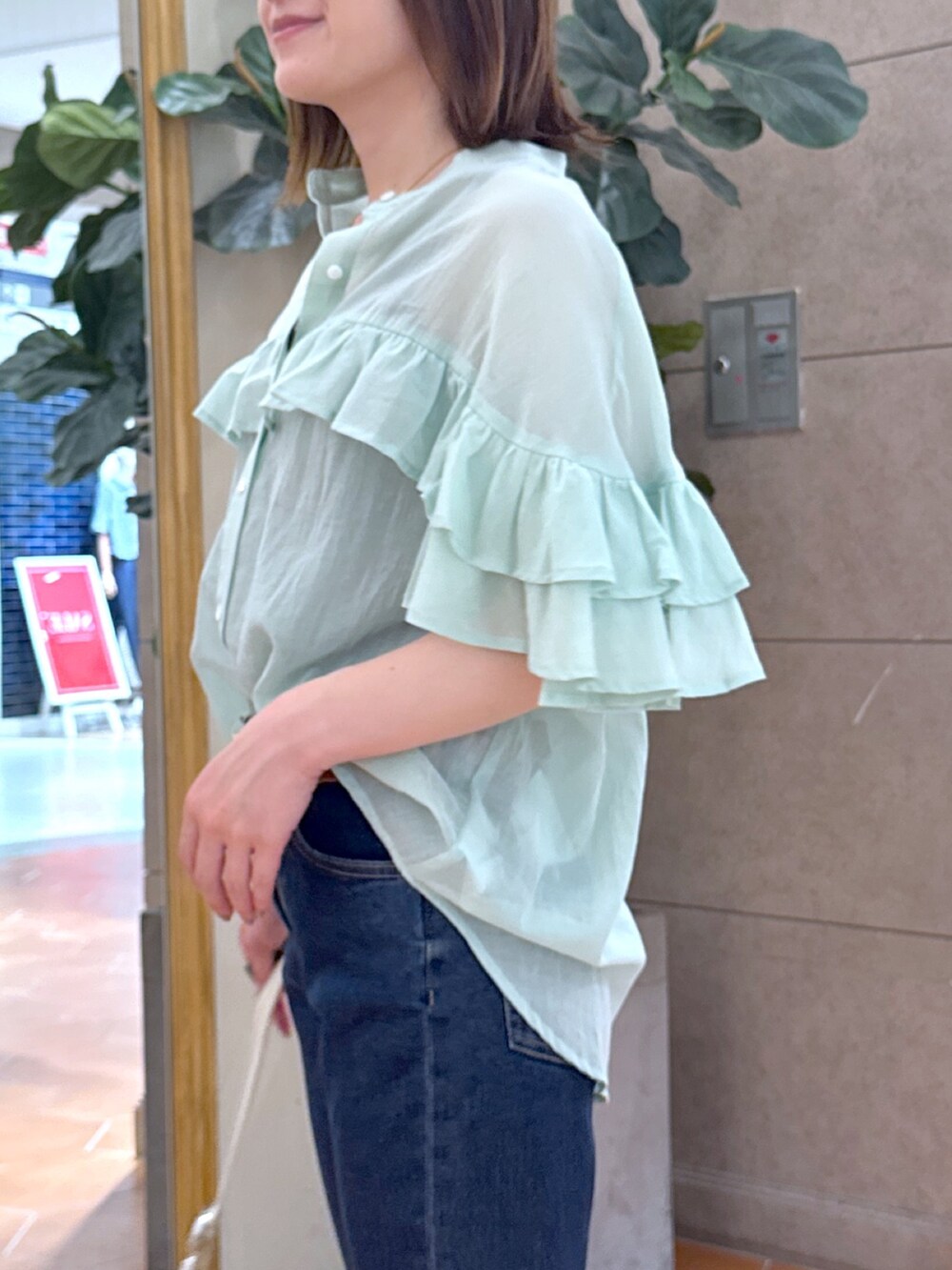 ブルー系のデニムパンツ、ベージュ系のサンダル、グリーン系のシャツ/ブラウスを着用したレディースの夏コーディネートの5枚目の写真