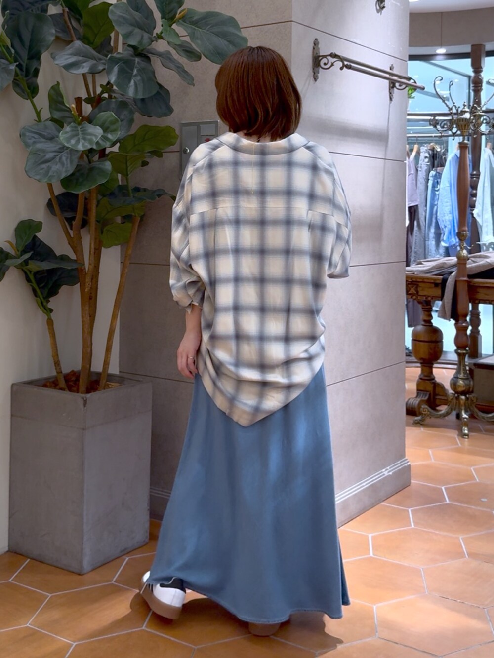 ブルー系のスカート、ベージュ系のシャツ/ブラウス、ゴールド系のネックレスを着用したレディースの夏コーディネートの3枚目の写真