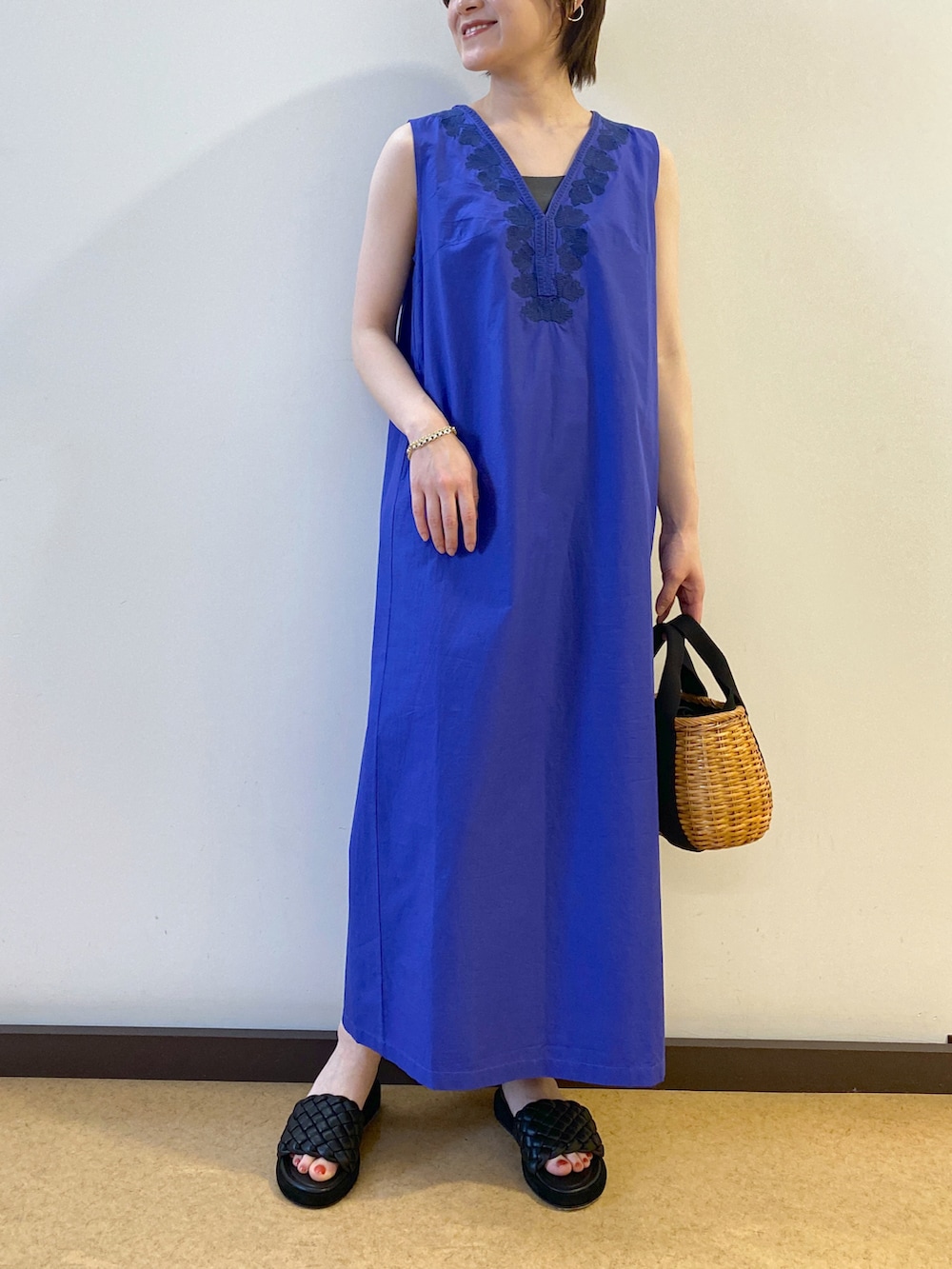 ブラック系のシャツ/ブラウス、ブルー系のワンピース、イエロー系のかごバッグを着用したレディースの春コーディネートの2枚目の写真