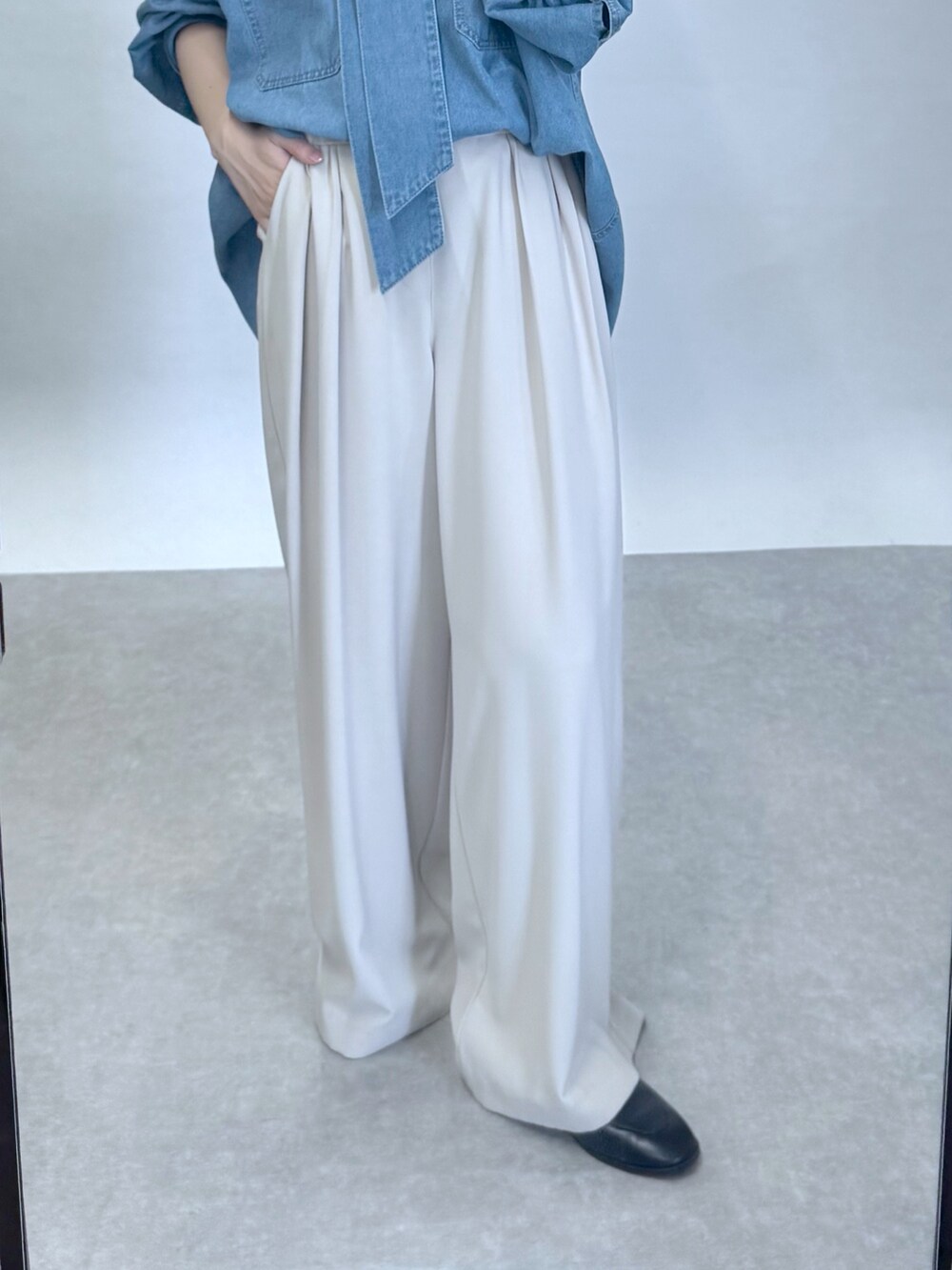 ブルー系のシャツ/ブラウス、グレー系のスラックス、ブラック系のローファーを着用したレディースの夏コーディネートの4枚目の写真