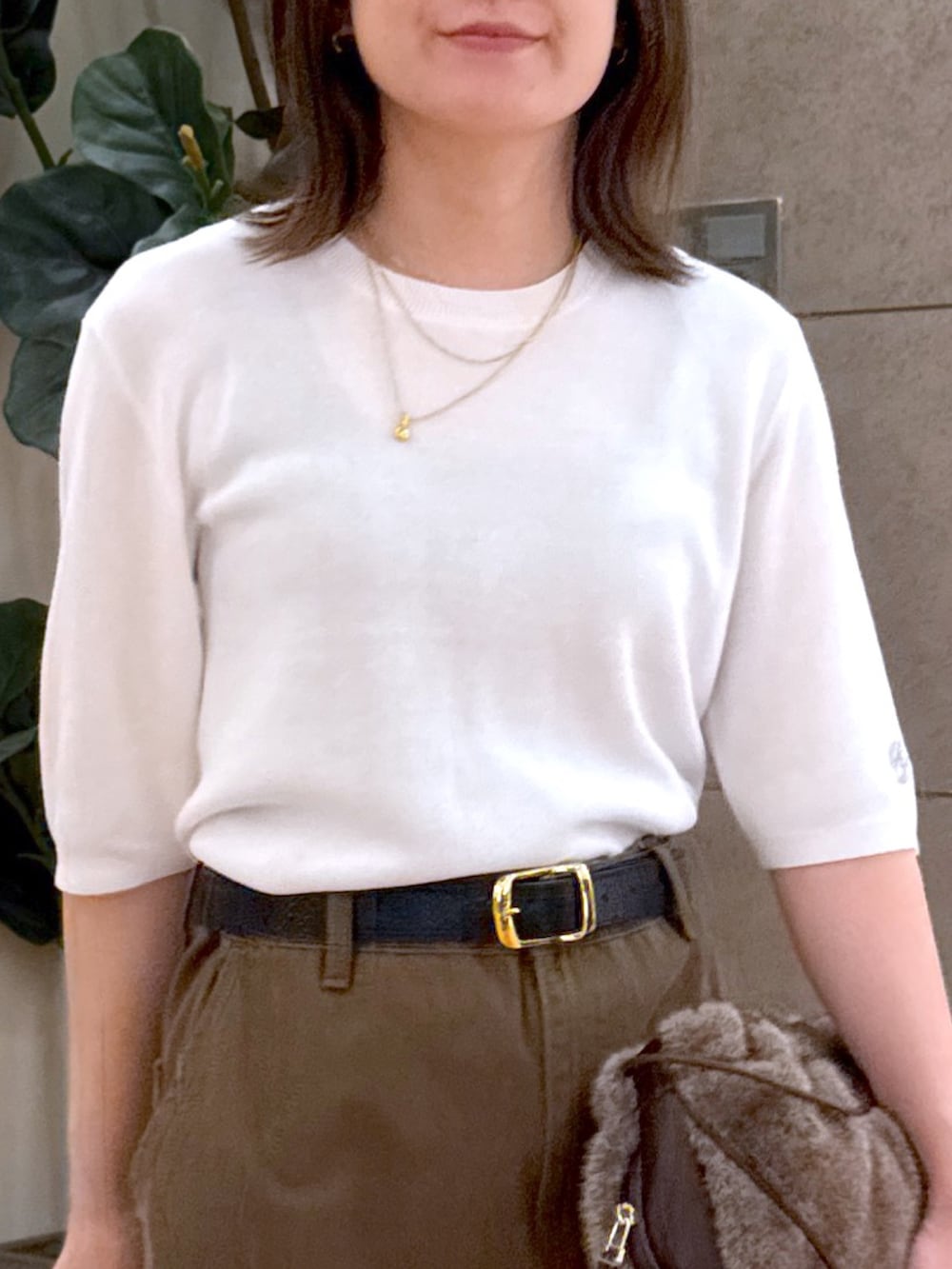 ホワイト系のニット/セーター、ブラウン系のスカート、ブラウン系のハンドバッグを着用したレディースの夏コーディネートの2枚目の写真