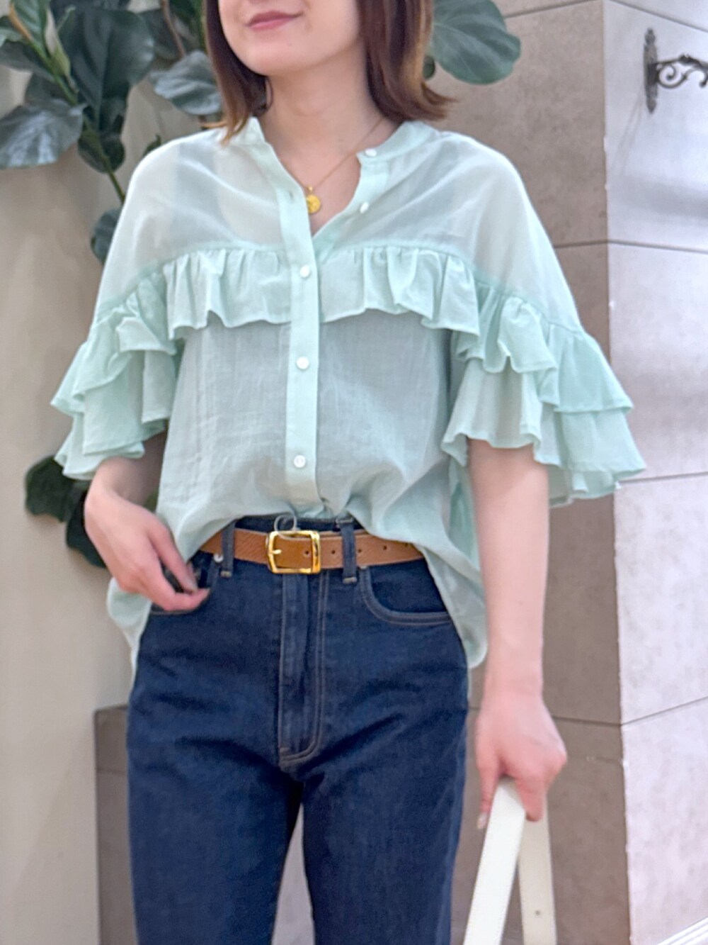 ブルー系のデニムパンツ、ベージュ系のサンダル、グリーン系のシャツ/ブラウスを着用したレディースの夏コーディネートの4枚目の写真