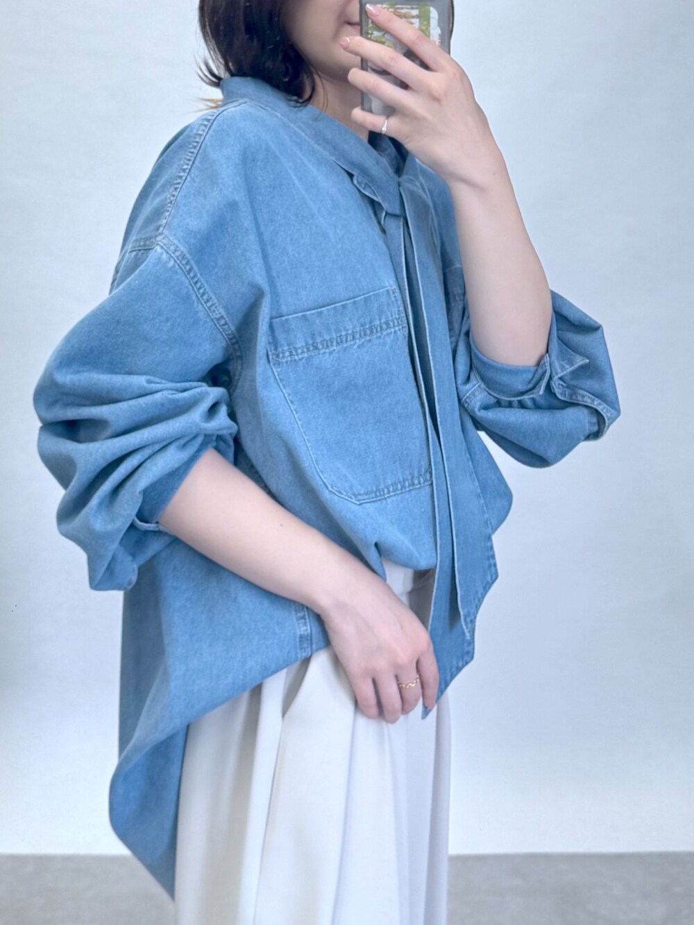 ブルー系のシャツ/ブラウス、グレー系のスラックス、ブラック系のローファーを着用したレディースの夏コーディネートの3枚目の写真