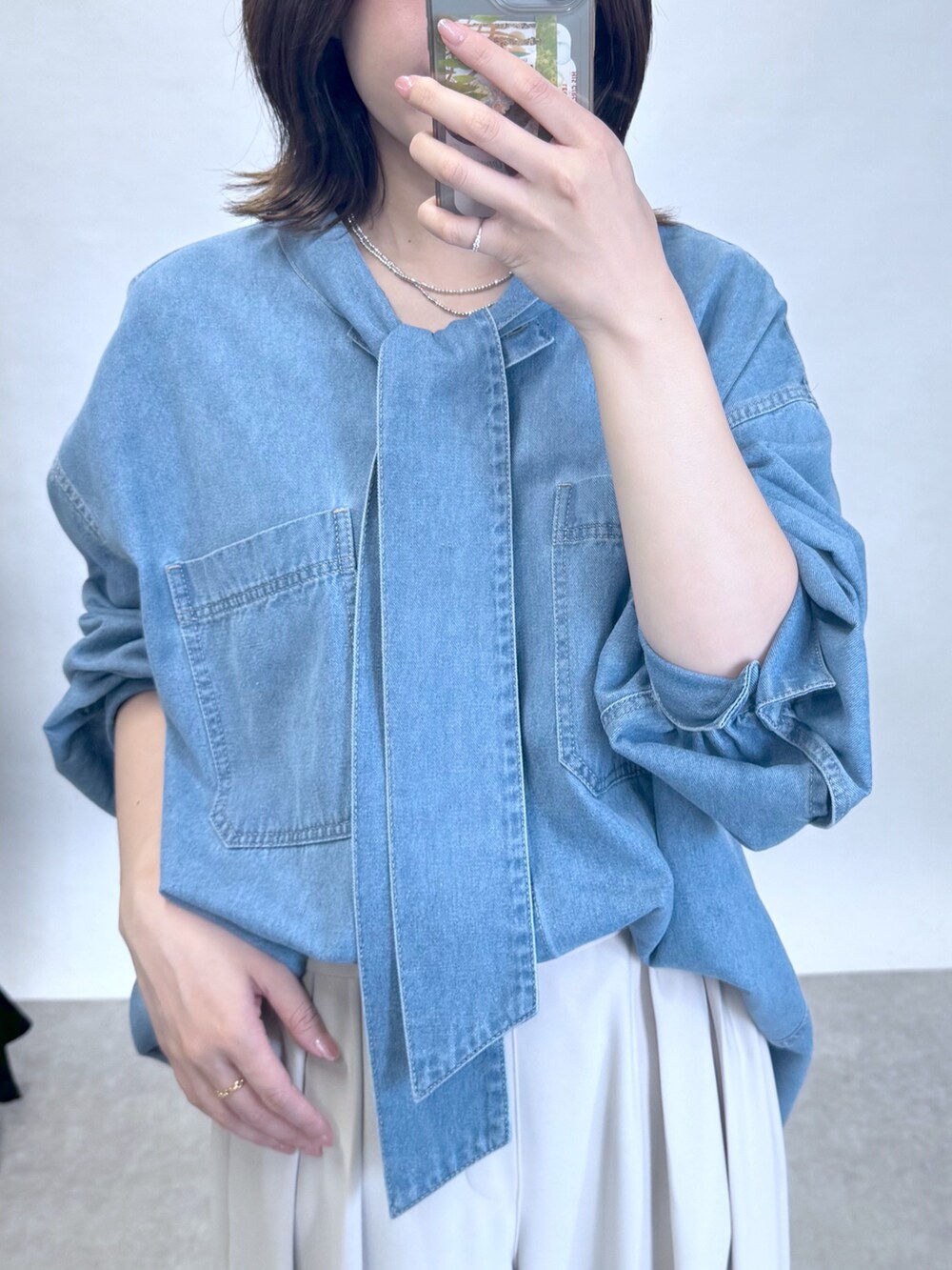 ブルー系のシャツ/ブラウス、グレー系のスラックス、ブラック系のローファーを着用したレディースの夏コーディネートの2枚目の写真