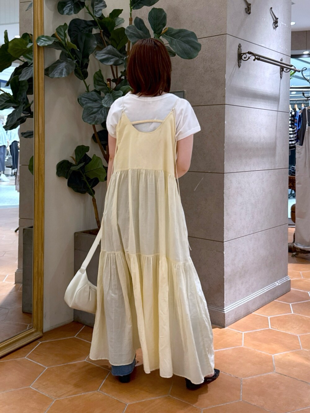 ホワイト系のTシャツ/カットソー、ホワイト系のワンピース、ホワイト系のハンドバッグを着用したレディースの夏コーディネートの2枚目の写真