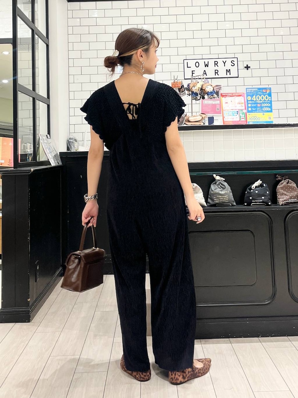 ブラウン系のボストンバッグ、その他のパンプス、ブラック系のサロペット/オーバーオールを着用したレディースの秋コーディネートの3枚目の写真