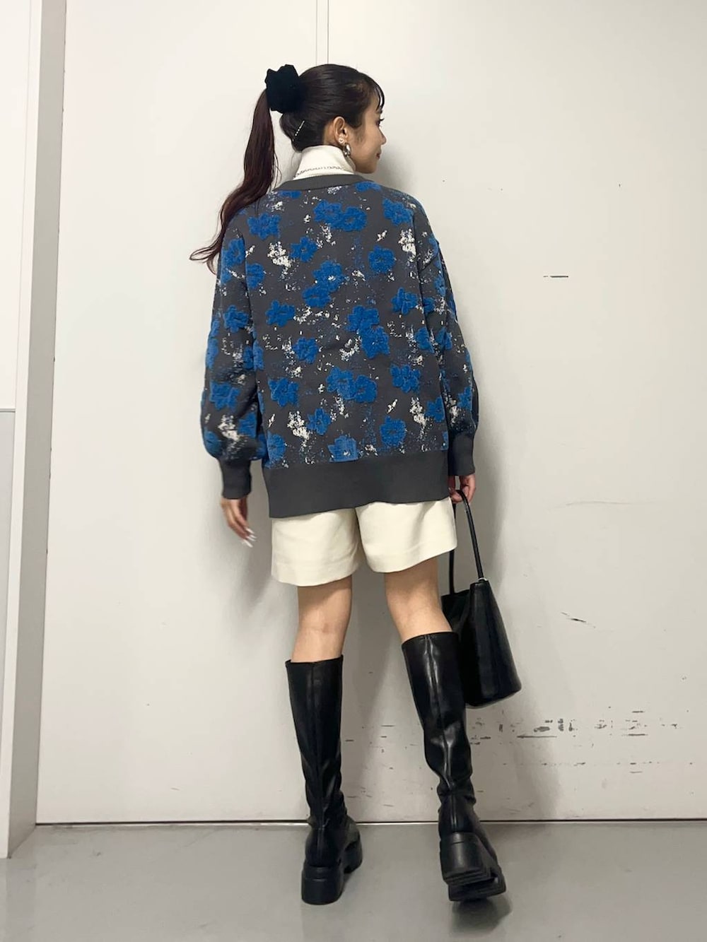 ホワイト系のニット/セーター、ブラック系のブーツ、ブルー系のカーディガン/ボレロを着用したレディースの冬コーディネートの3枚目の写真