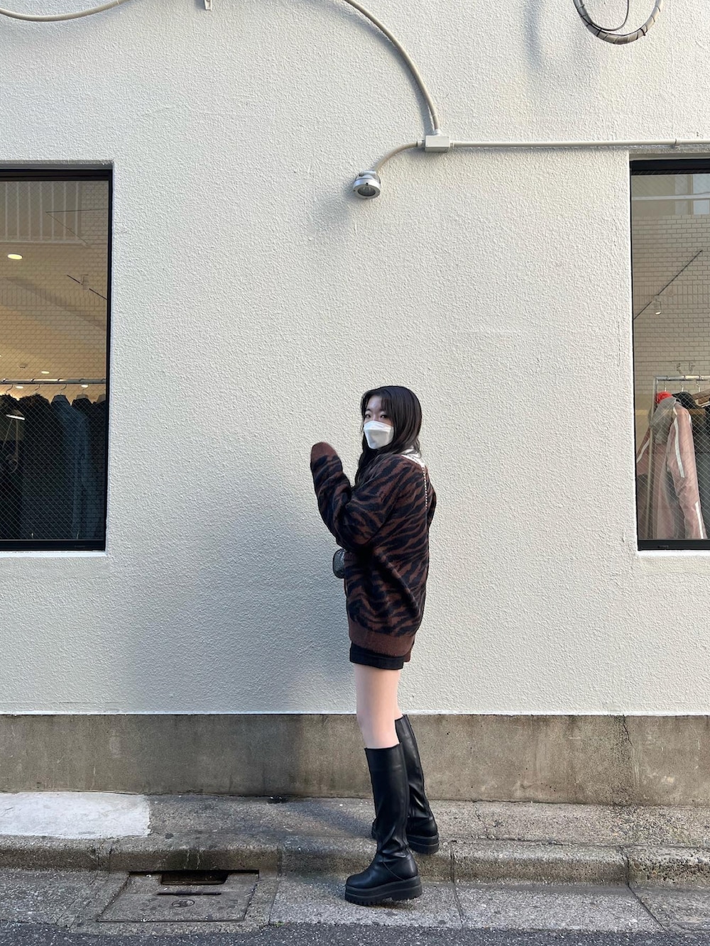 ブラック系のブルゾン、ブラック系のショルダーバッグ、ブラウン系のカーディガン/ボレロを着用したレディースの冬コーディネートの3枚目の写真