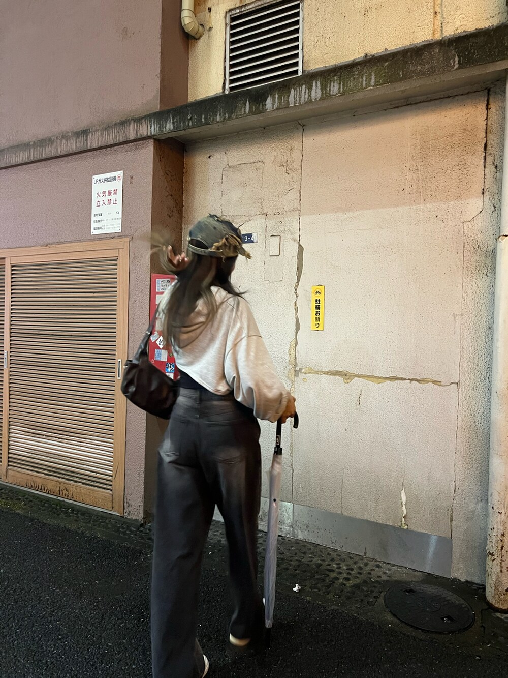 ブラウン系のショルダーバッグ、ホワイト系のスニーカー、その他のキャップを着用したレディースの秋コーディネートの2枚目の写真