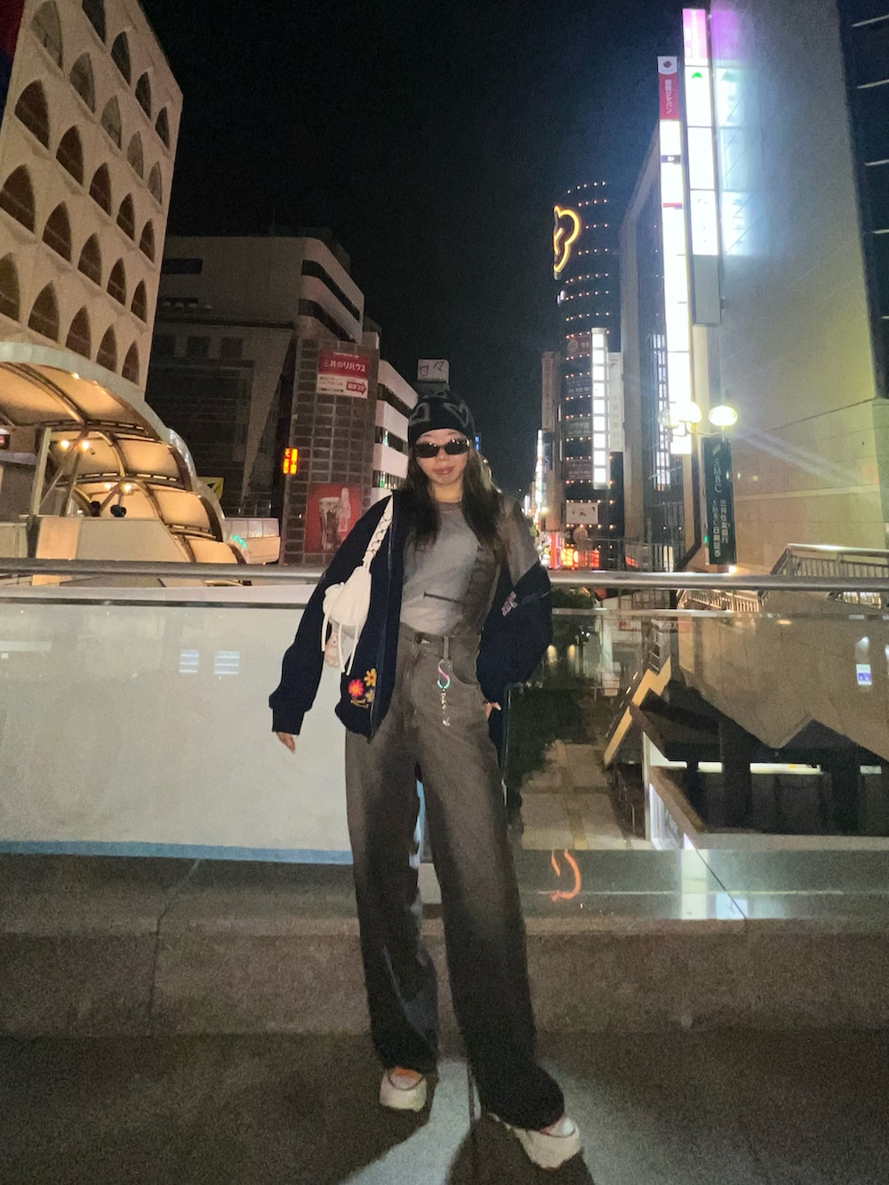 ブルー系のパーカー、ホワイト系のショルダーバッグ、オレンジ系のスニーカーを着用したレディースの冬コーディネートの2枚目の写真