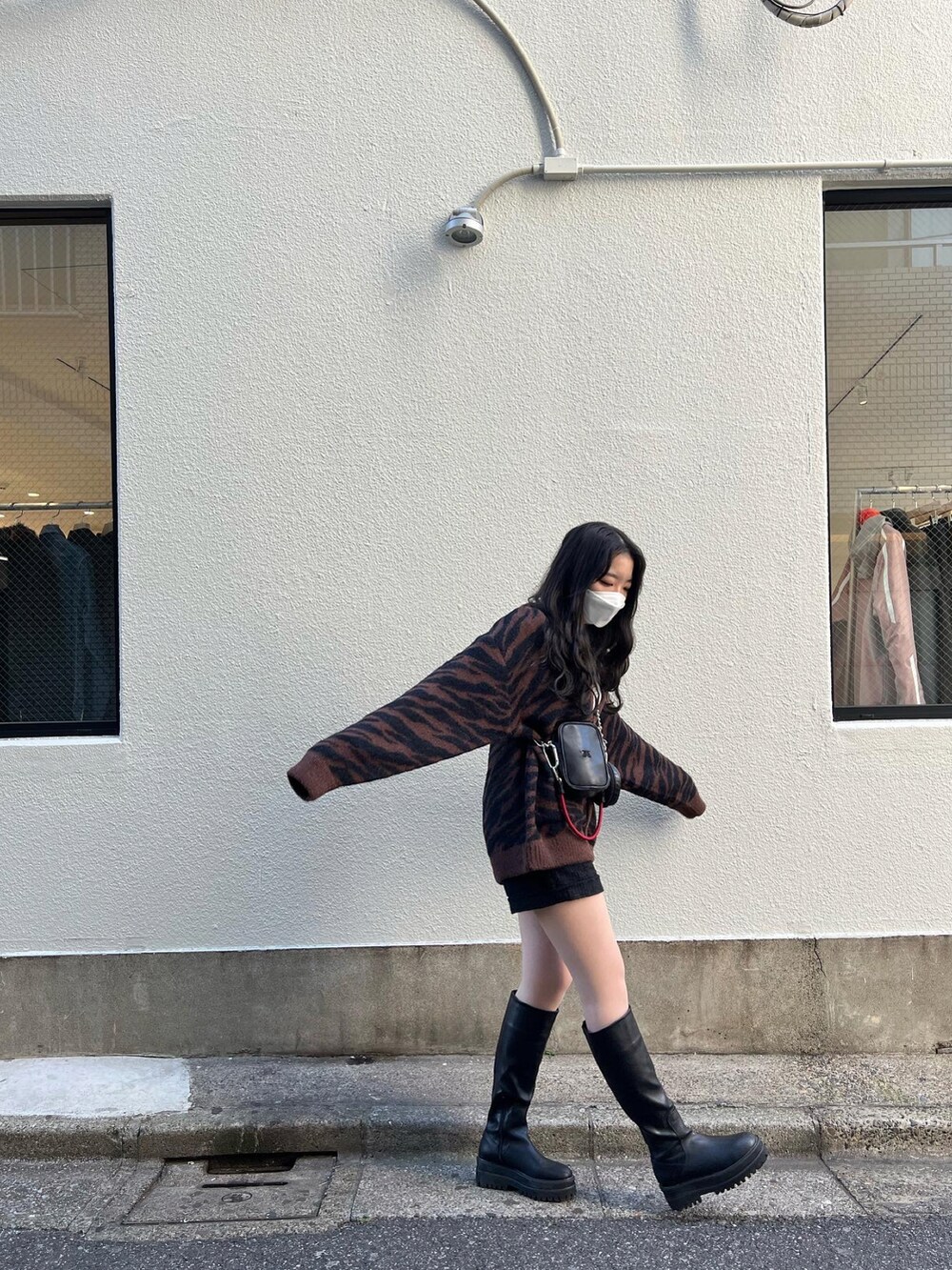 ブラック系のブルゾン、ブラック系のショルダーバッグ、ブラウン系のカーディガン/ボレロを着用したレディースの冬コーディネートの2枚目の写真