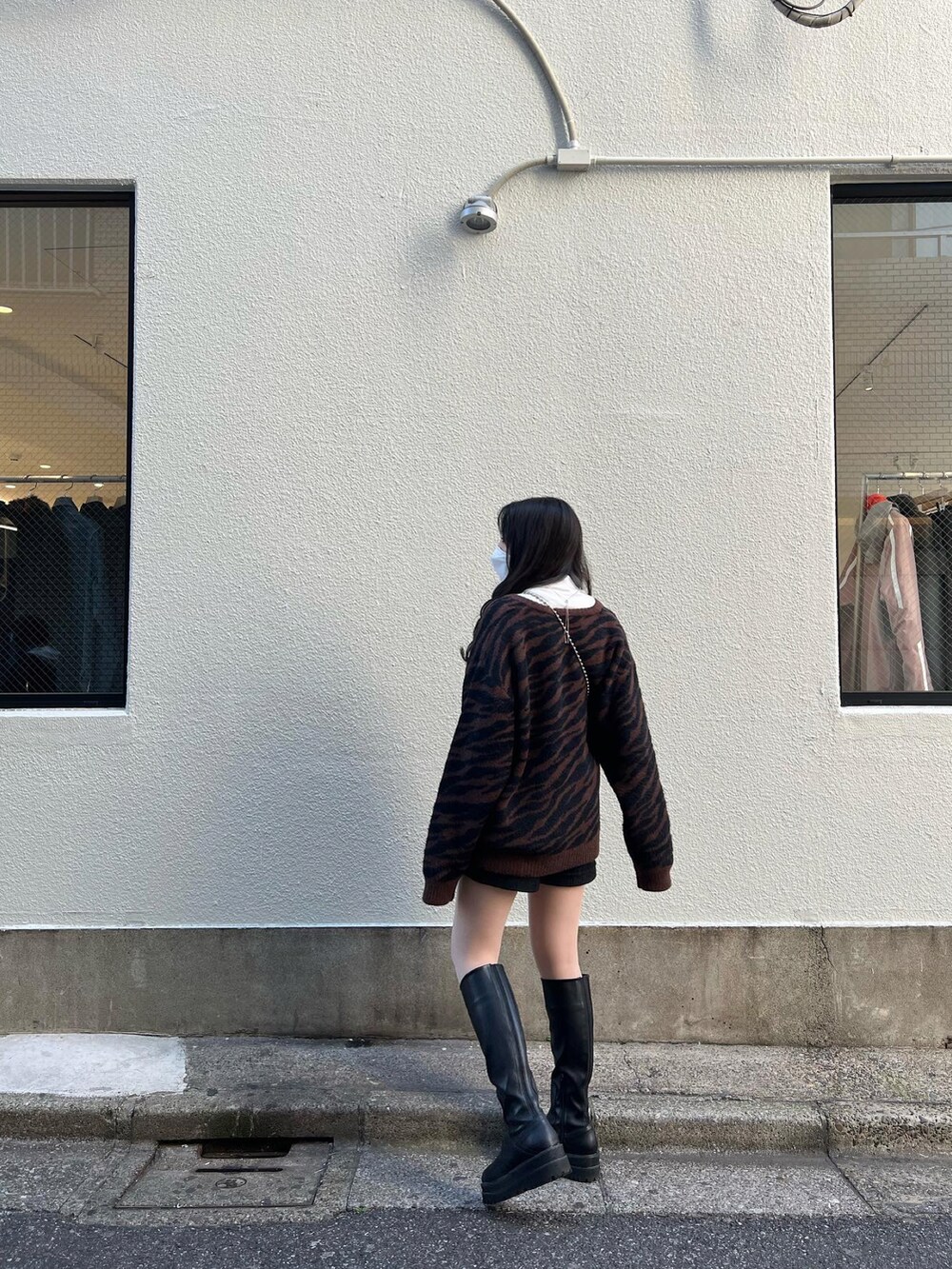 ブラック系のブルゾン、ブラック系のショルダーバッグ、ブラウン系のカーディガン/ボレロを着用したレディースの冬コーディネートの4枚目の写真