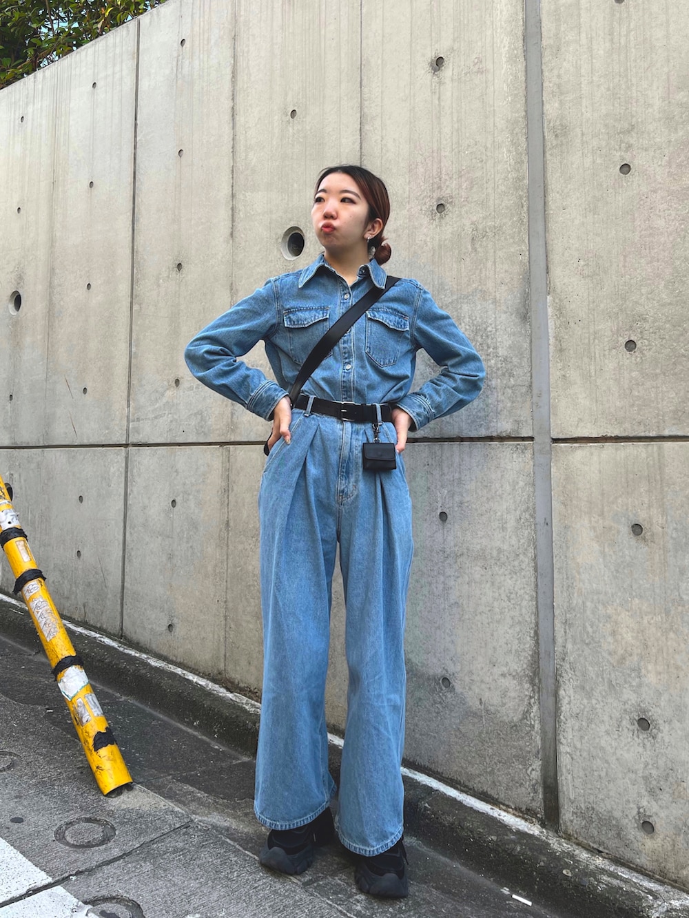 ブルー系のシャツ/ブラウス、ブラック系のショルダーバッグ、ブルー系のデニムパンツを着用したレディースの春コーディネートの2枚目の写真