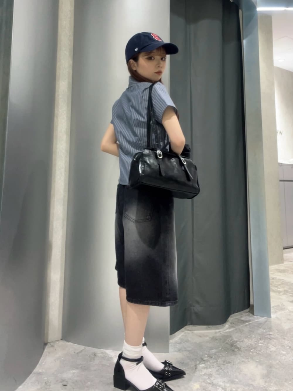 ブラック系のショルダーバッグ、ブルー系のシャツ/ブラウス、ブラック系のデニムパンツを着用したレディースの夏コーディネートの2枚目の写真