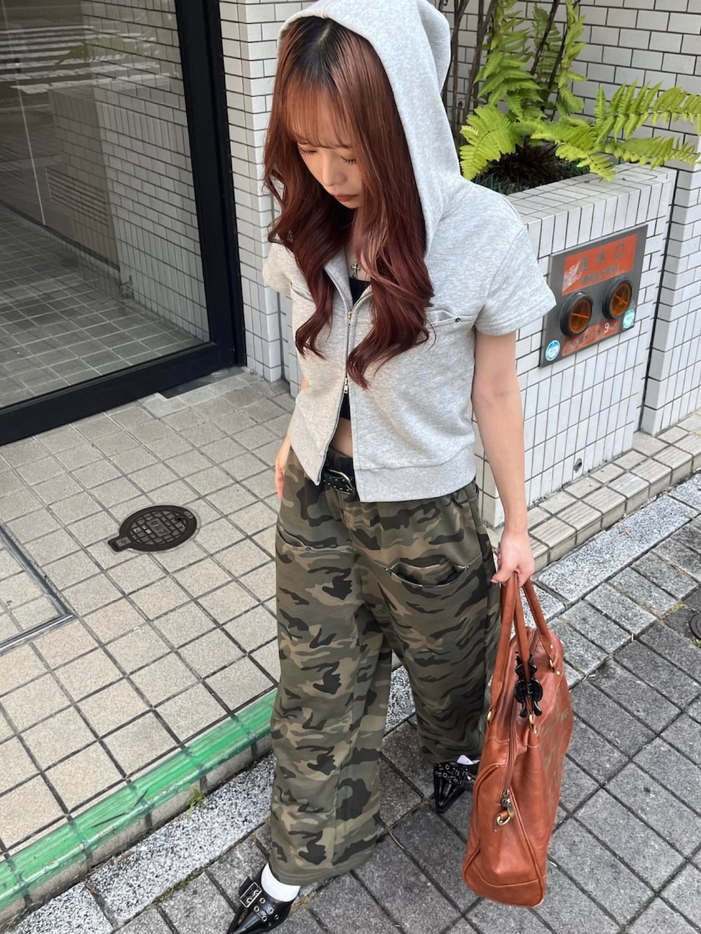 グレー系のパーカー、グリーン系のスウェットパンツ、ブラック系のパンプスを着用したレディースの夏コーディネートの4枚目の写真