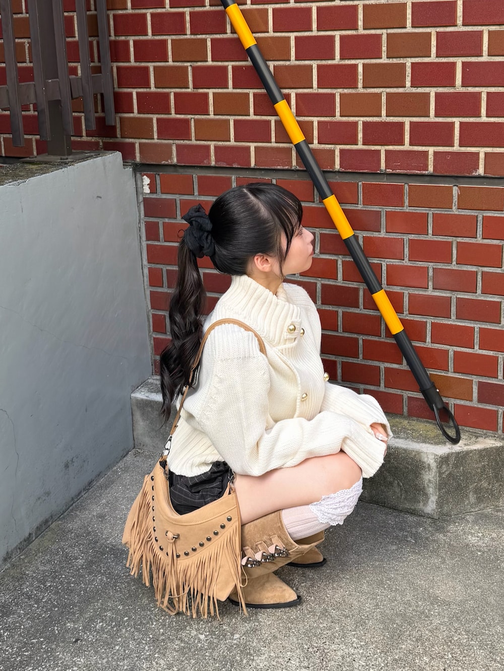 ホワイト系のニット/セーター、ブラウン系のパンツ、ベージュ系のブーツを着用したレディースの夏コーディネートの3枚目の写真