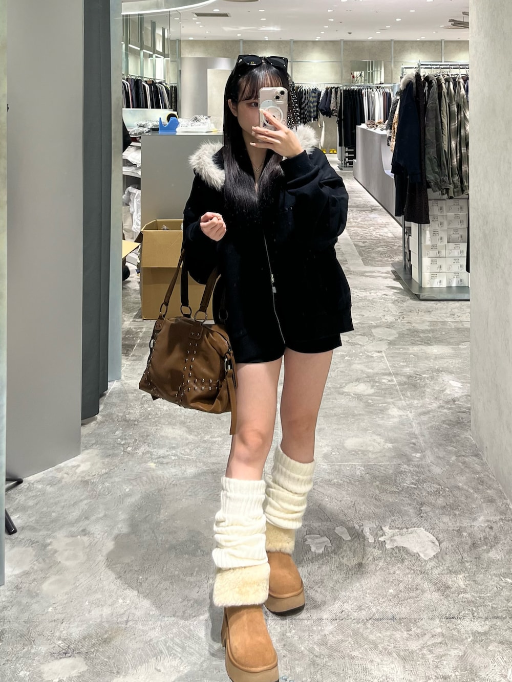 ブラック系のパーカー、ブラック系のその他パンツ、ブラウン系のショルダーバッグを着用したレディースの秋コーディネートの3枚目の写真