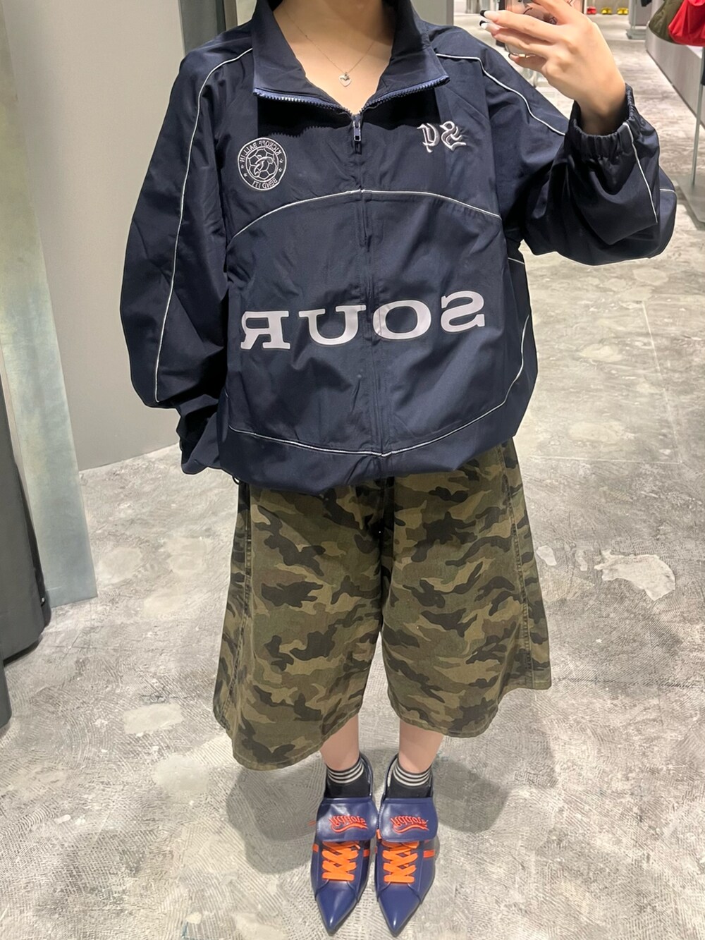 ブルー系のブルゾン、グリーン系のチノパンツ、ブラック系のショルダーバッグを着用したレディースの秋コーディネートの2枚目の写真