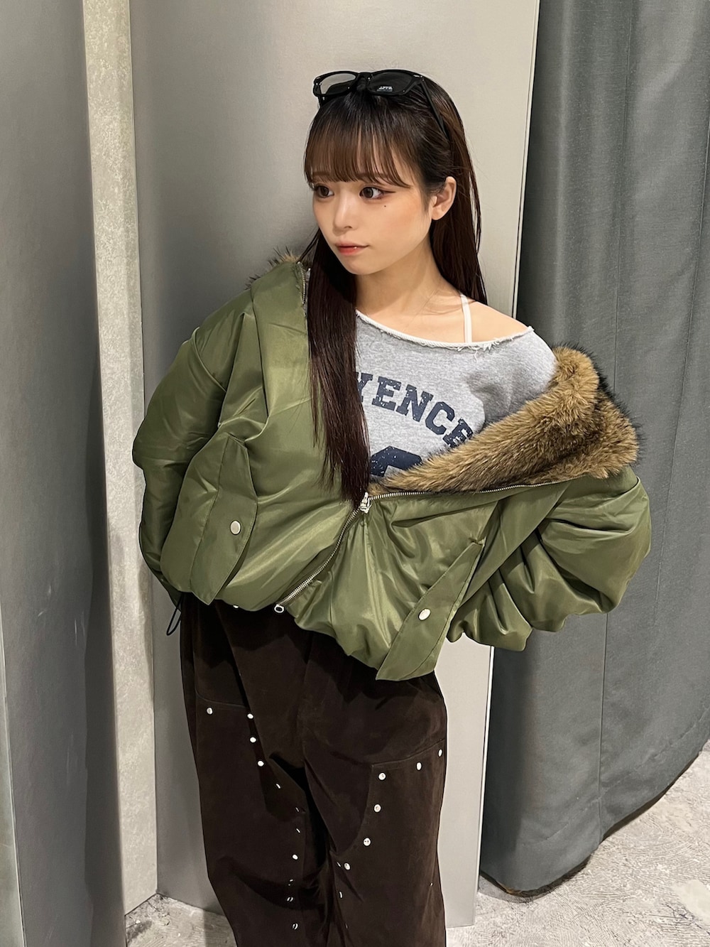 グリーン系のブルゾン、グレー系のスウェット、ブラウン系のパンツを着用したレディースの秋コーディネートの3枚目の写真