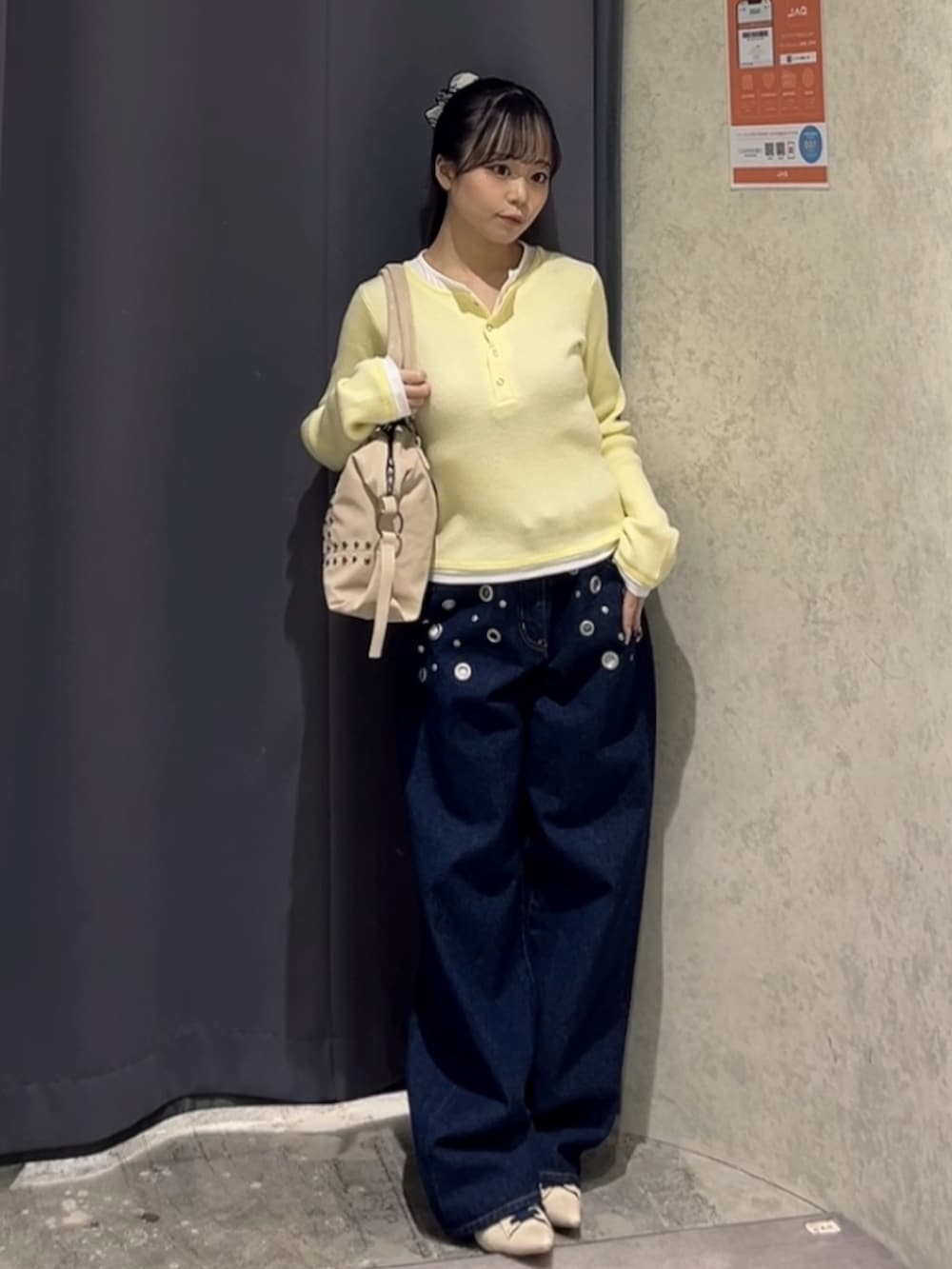 イエロー系のニット/セーター、ブルー系のデニムパンツ、ホワイト系のパンプスを着用したレディースの冬コーディネートの2枚目の写真