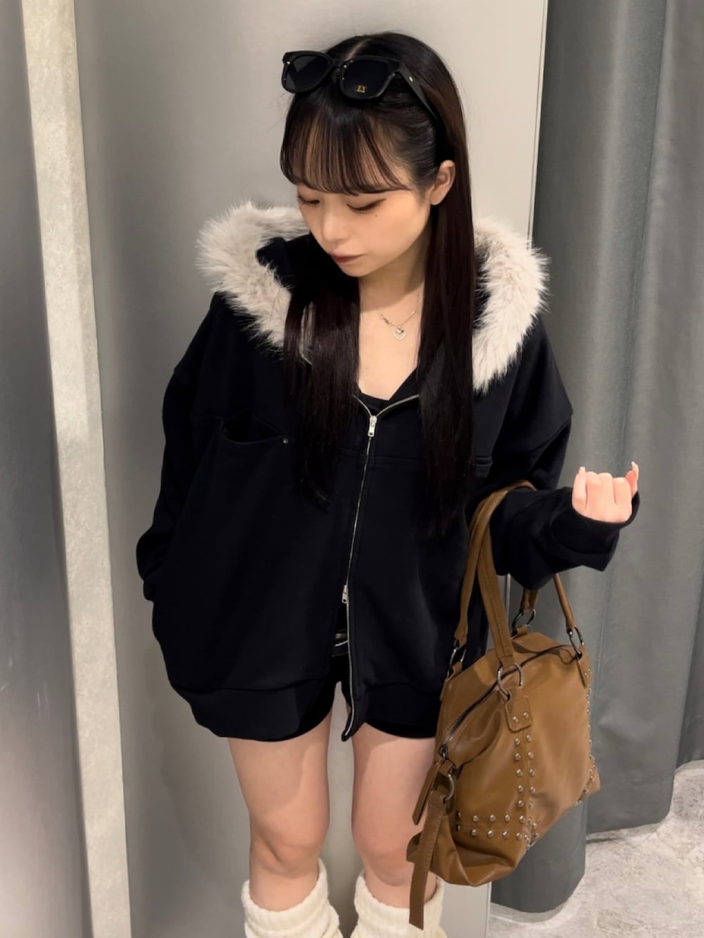 ブラック系のパーカー、ブラック系のその他パンツ、ブラウン系のショルダーバッグを着用したレディースの秋コーディネートの2枚目の写真
