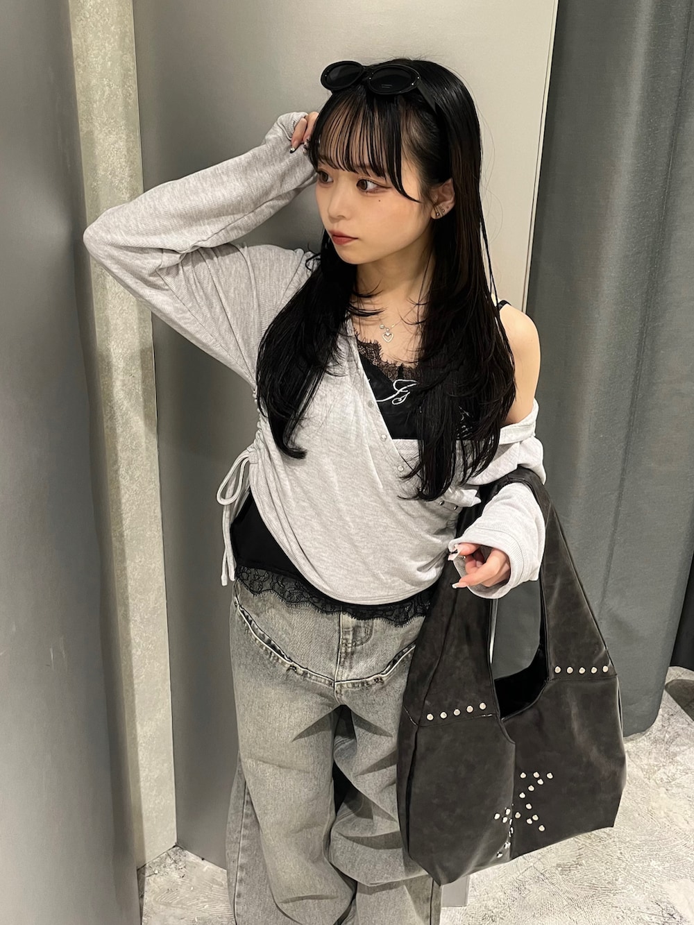 グレー系のトップス、ブラック系のキャミソール、グレー系のデニムパンツを着用したレディースの春コーディネートの3枚目の写真