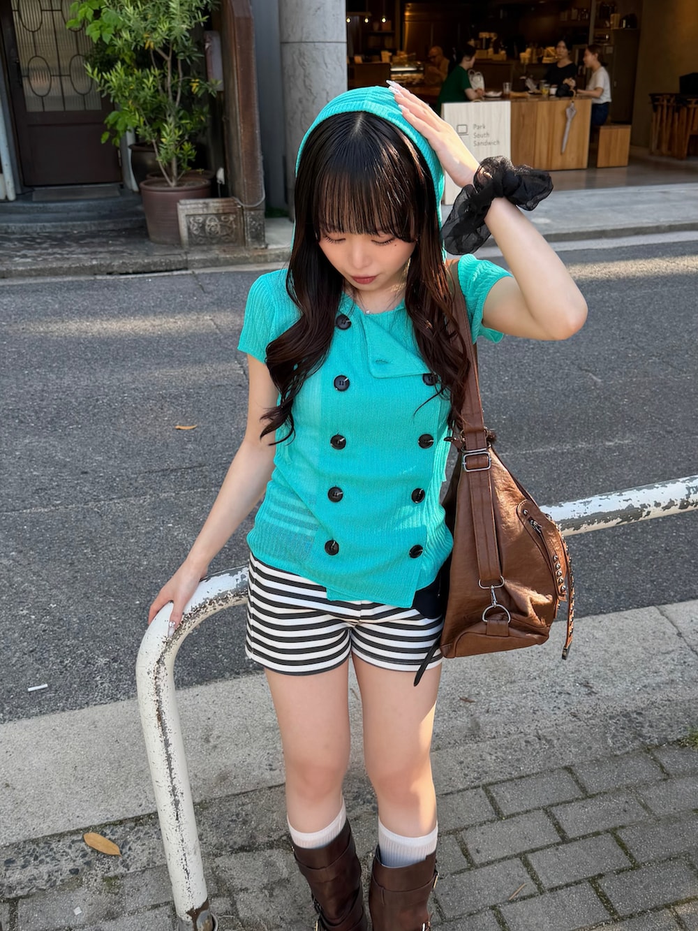 ブルー系のパーカー、ホワイト系のその他パンツ、ブラウン系のブーツを着用したレディースの夏コーディネートの3枚目の写真