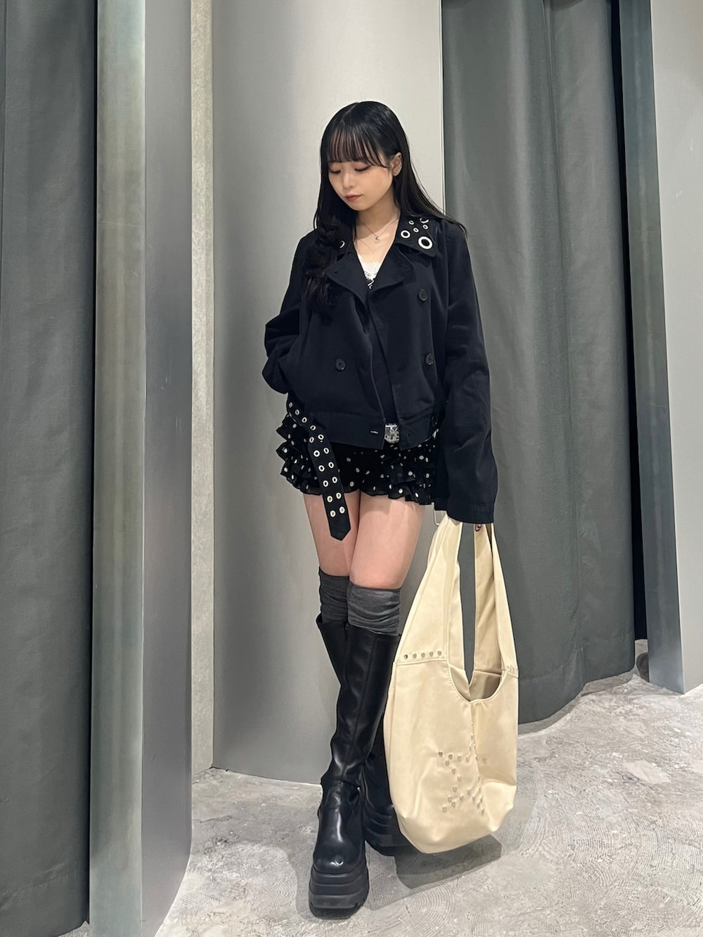 ブラック系のピーコート、ブルー系のキャミソール、ブラック系のその他パンツを着用したレディースの春コーディネートの2枚目の写真