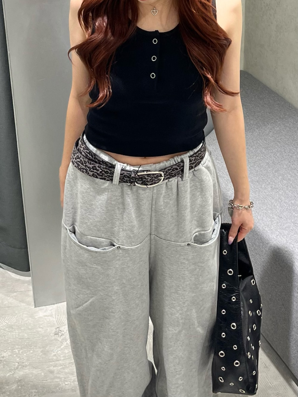 ブラック系のタンクトップ、グレー系のスウェットパンツ、ブラック系のショルダーバッグを着用したレディースの夏コーディネートの3枚目の写真