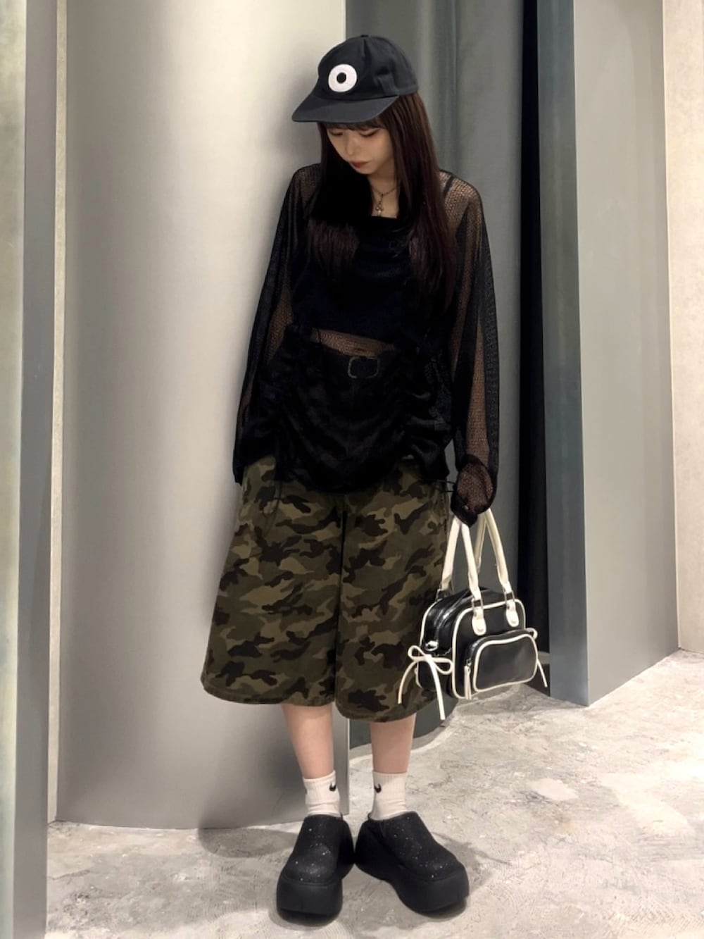 ブラック系のTシャツ/カットソー、グリーン系のチノパンツ、ブラック系のショルダーバッグを着用したレディースの秋コーディネートの2枚目の写真