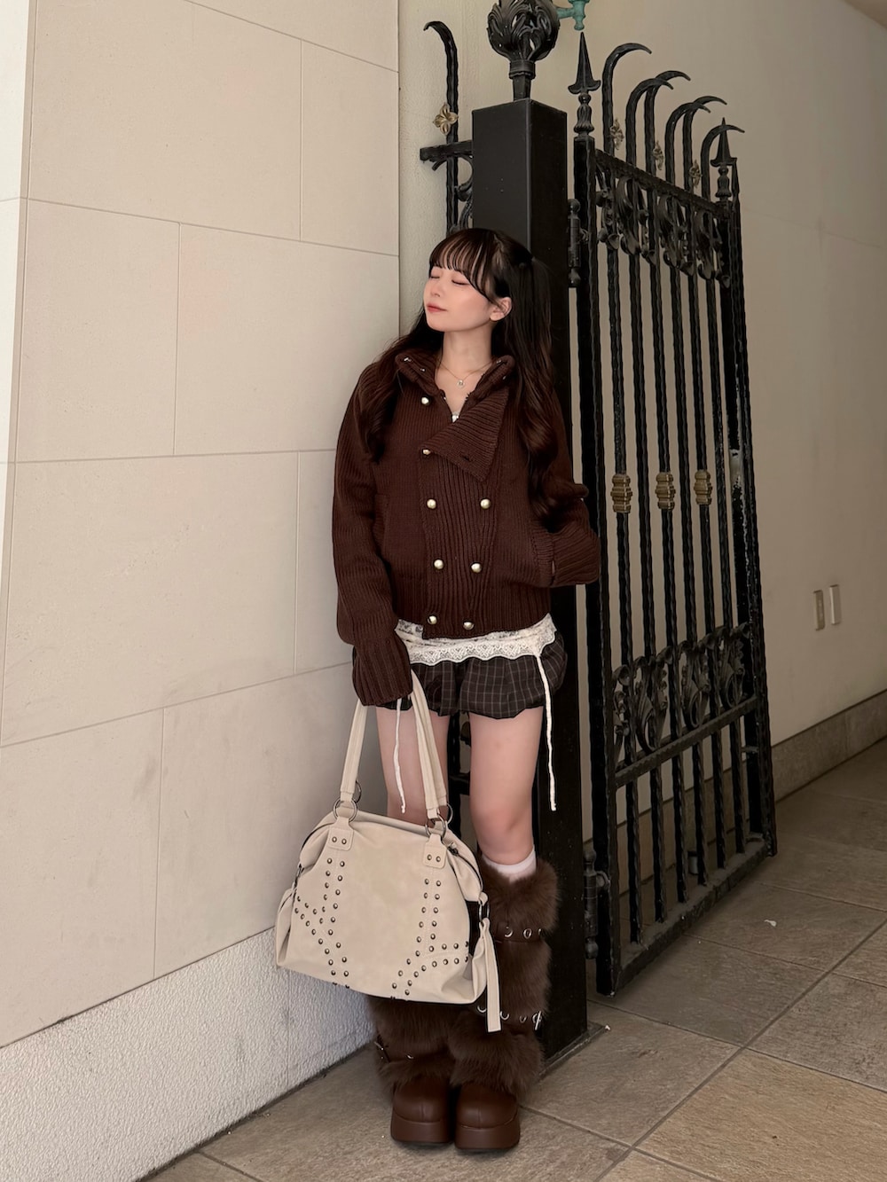 ブラウン系のニット/セーター、ホワイト系のキャミソール、ブラウン系のパンツを着用したレディースの秋コーディネートの2枚目の写真