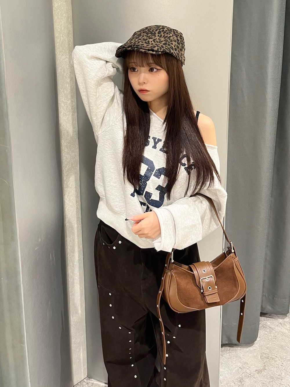 グレー系のスウェット、ブラウン系のショルダーバッグ、ブラウン系のパンツを着用したレディースの秋コーディネートの3枚目の写真