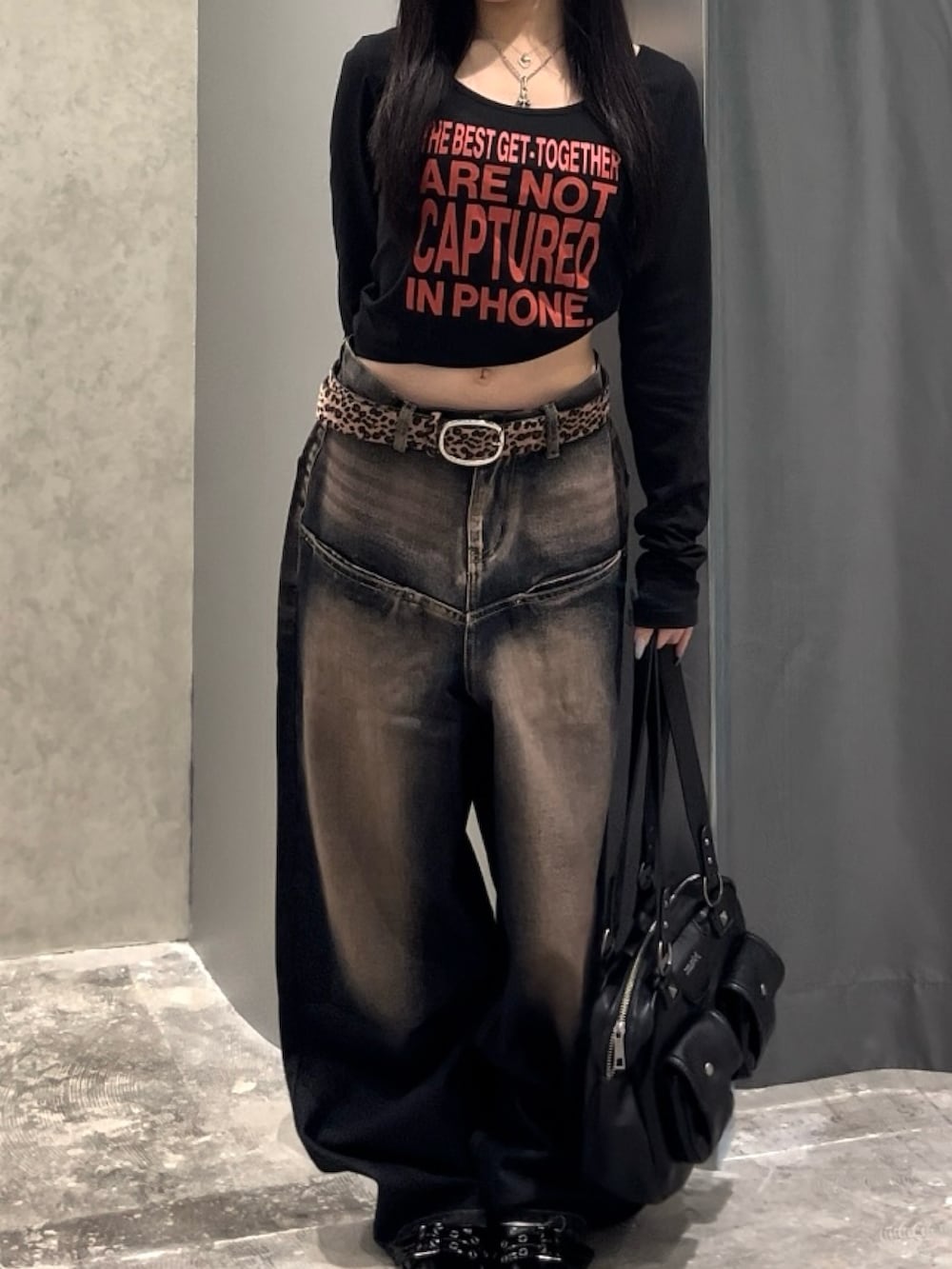 ブラック系のTシャツ/カットソー、ブルー系のデニムパンツ、ブラック系のパンプスを着用したレディースの秋コーディネートの4枚目の写真