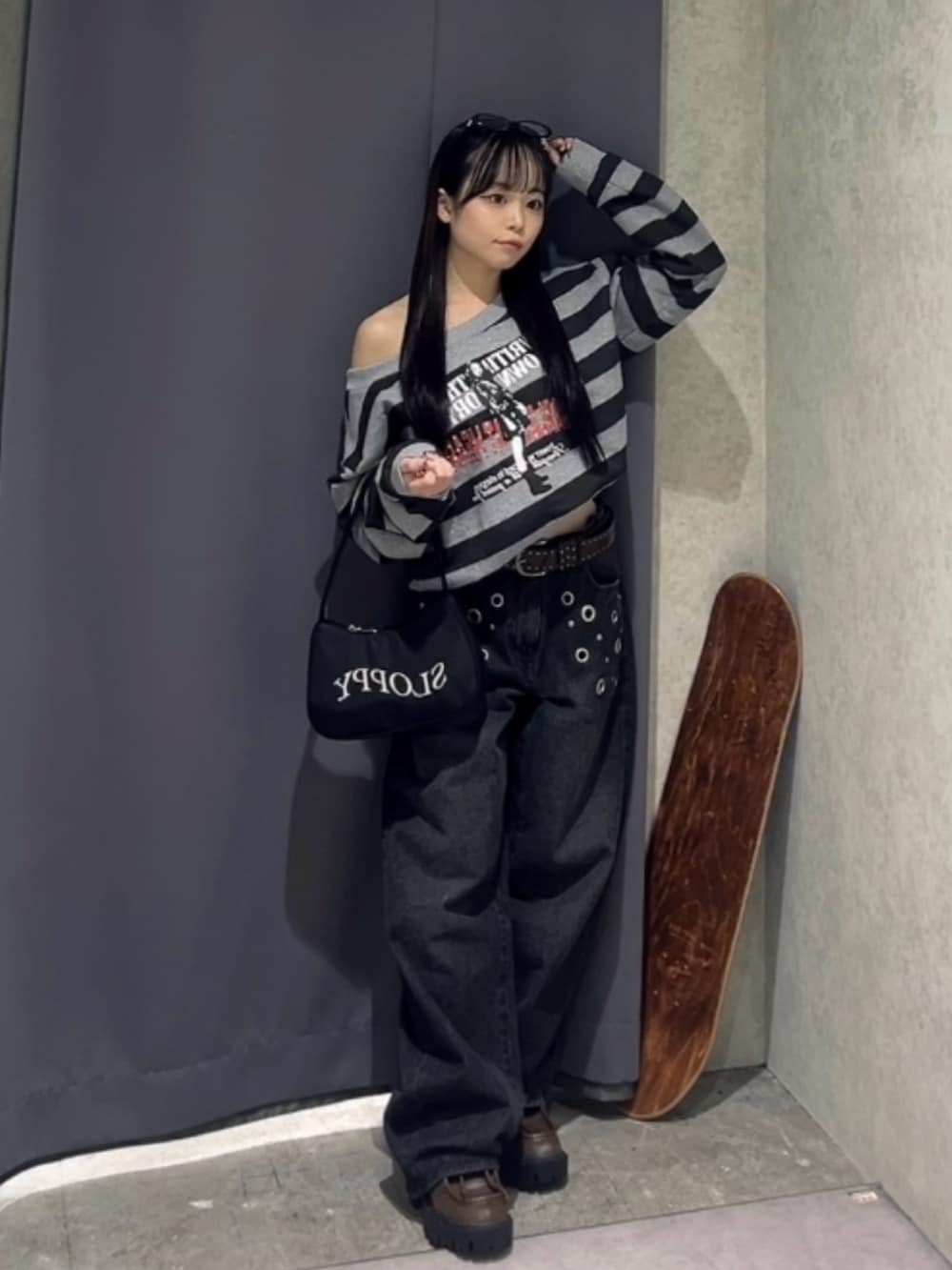 グレー系のスウェット、ブラック系のデニムパンツ、ブラウン系のローファーを着用したレディースの冬コーディネートの3枚目の写真