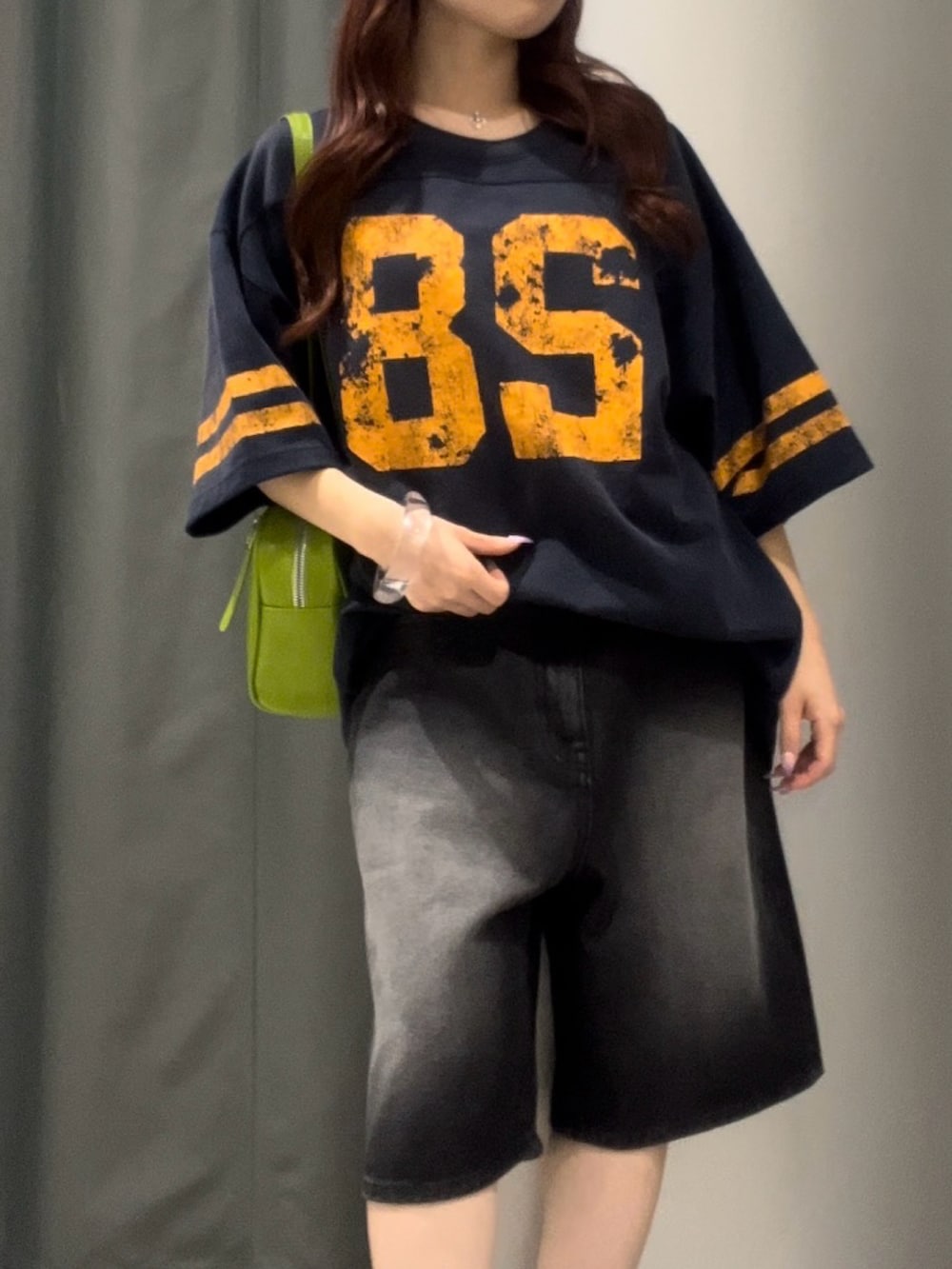ブラック系のデニムパンツ、グリーン系のショルダーバッグ、ブルー系のTシャツ/カットソーを着用したレディースの夏コーディネートの3枚目の写真