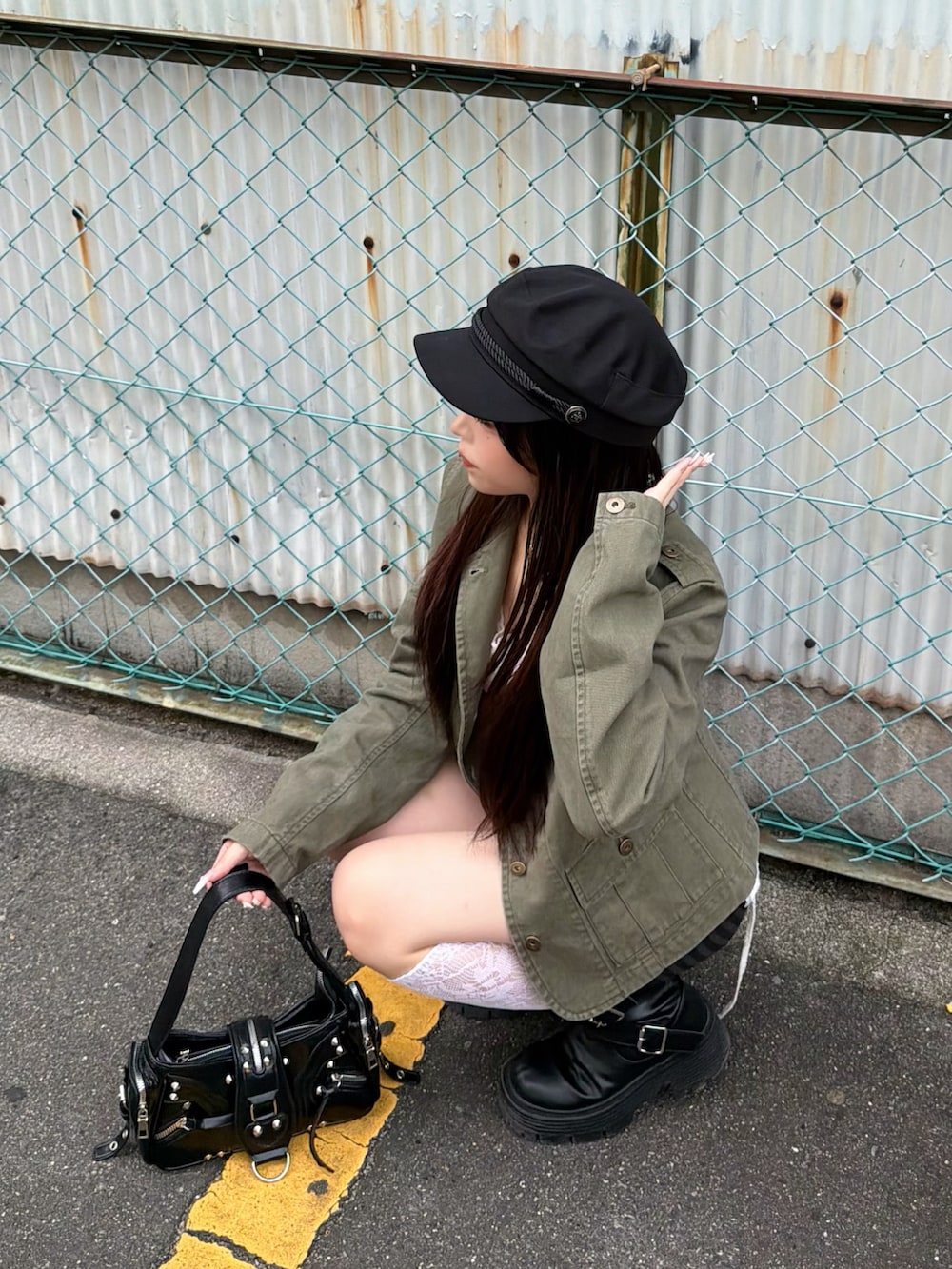 グリーン系のミリタリージャケット、ホワイト系のキャミソール、ブラック系のその他パンツを着用したレディースの夏コーディネートの5枚目の写真