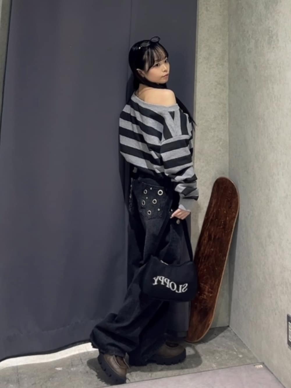 グレー系のスウェット、ブラック系のデニムパンツ、ブラウン系のローファーを着用したレディースの冬コーディネートの2枚目の写真