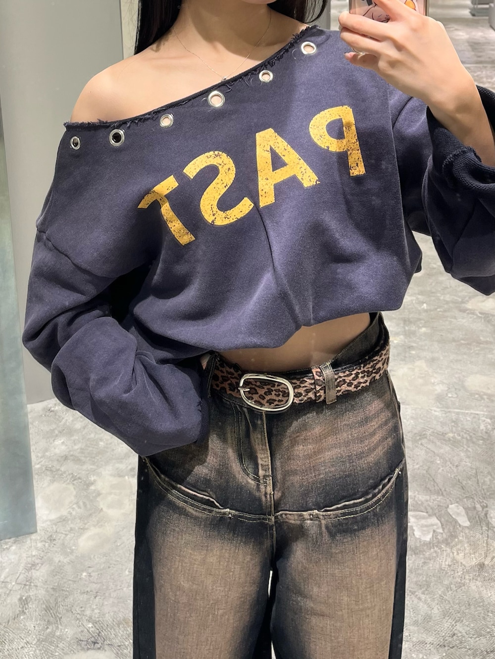 ブルー系のスウェット、ブルー系のデニムパンツ、ブラウン系のショルダーバッグを着用したレディースの秋コーディネートの3枚目の写真