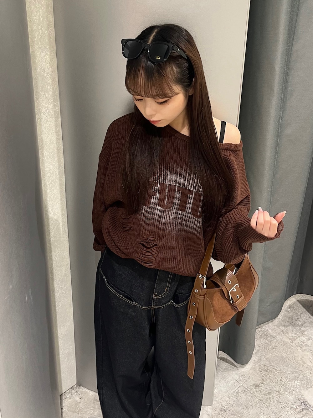 ブラウン系のニット/セーター、ブルー系のデニムパンツ、ブラウン系のショルダーバッグを着用したレディースの秋コーディネートの3枚目の写真